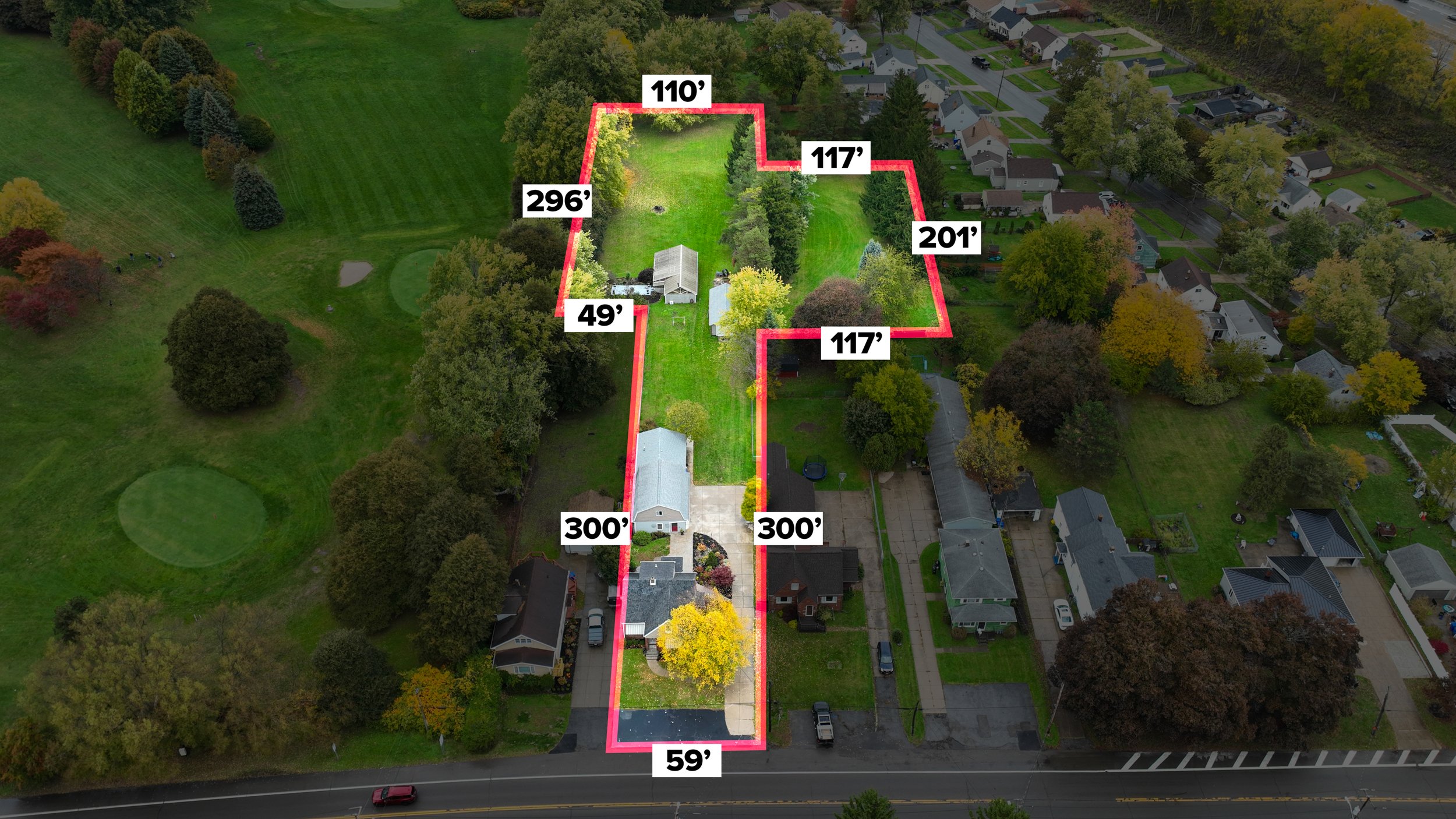 Aerial view of a landscaped residential backyard outlined with a red border, showing various trees, a lawn, a patio, and buildings. Measurement labels indicate the dimensions of the property along the borders.