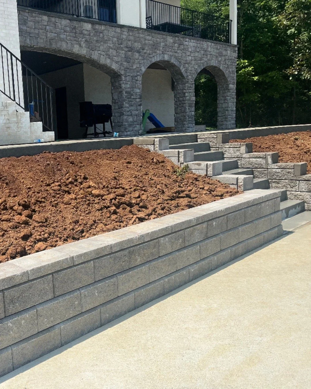 Retaining walls are often seen as purely structural, but in the right design they become part of the visual statement. They frame the space, anchor the layout, and give the entire landscape a sense of permanence.