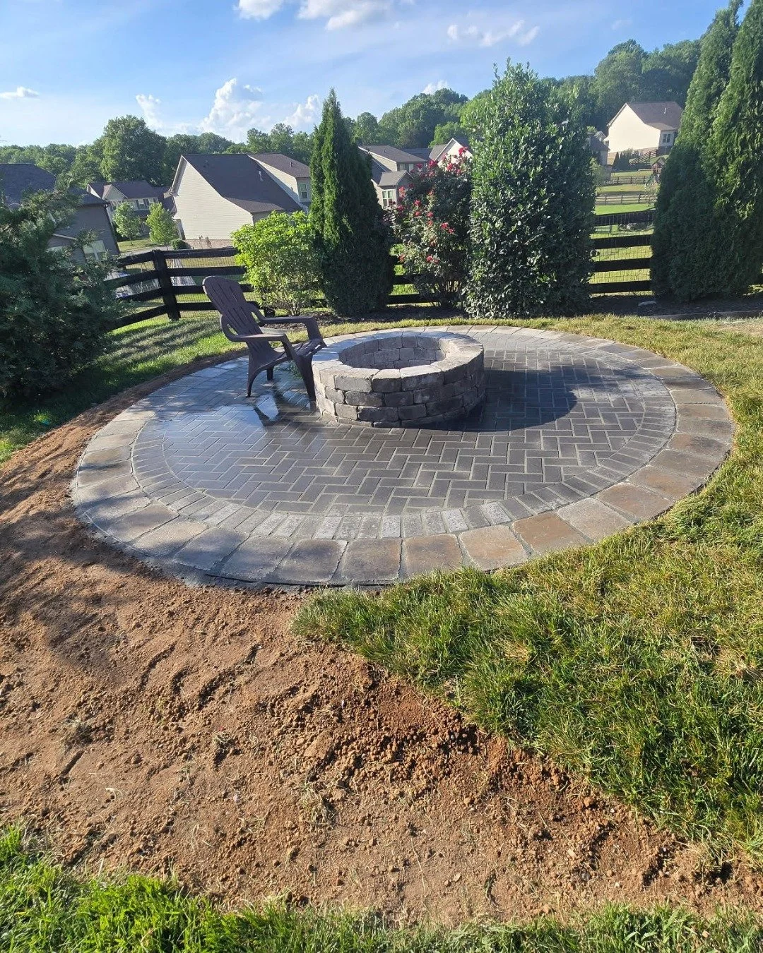 Every yard has that one spot that just sits there. You walk past it, mow around it, and never really think about what it could be.

This one became a circular paver patio with a built-in fire pit, tucked into a corner with just enough separation from