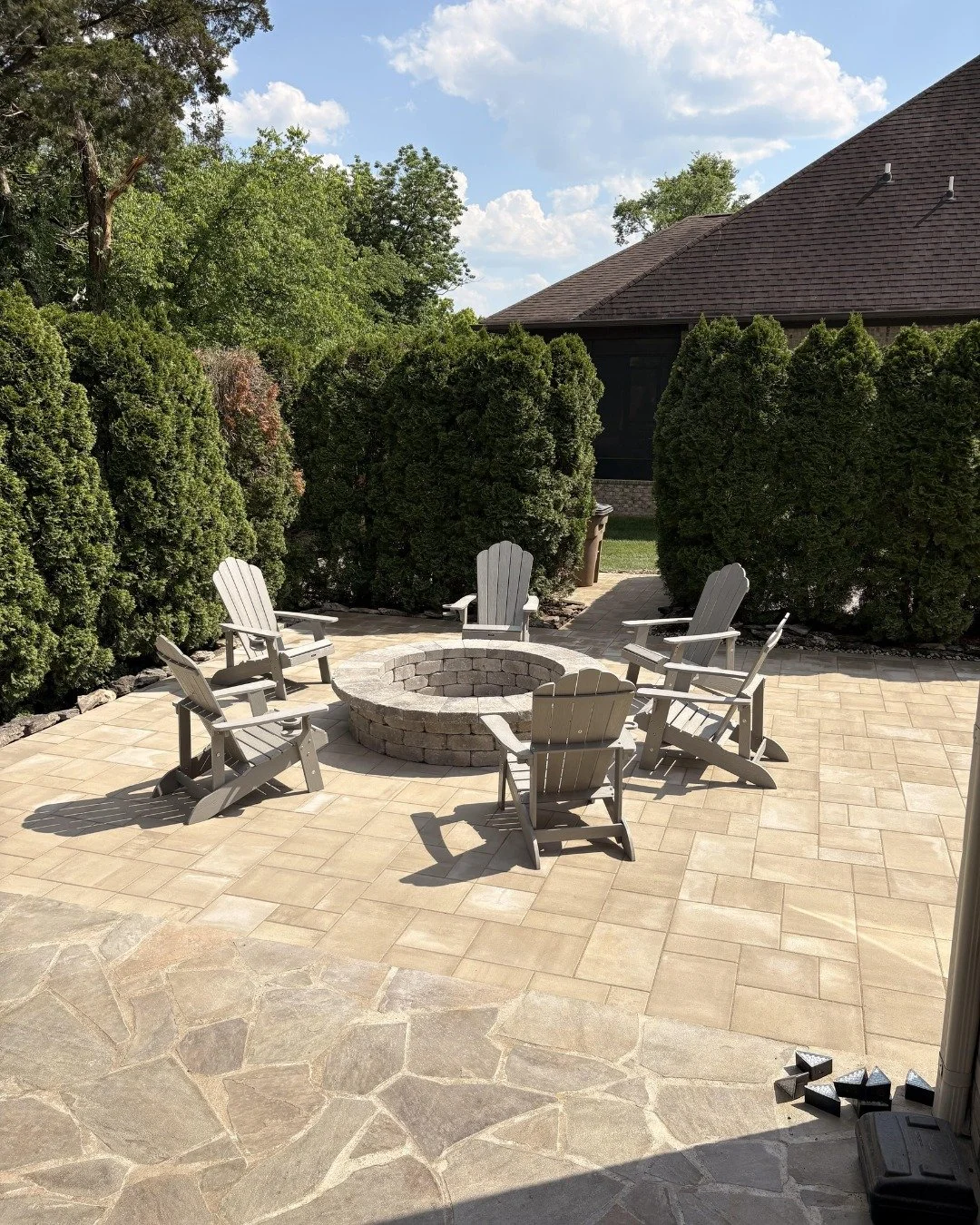 The existing flagstone patio was great. The goal wasn't to replace it; it was to extend the story.

We added a secondary paver patio anchored by an oversized fire pit, and picked a paver that works alongside the flagstone instead of fighting it. Same