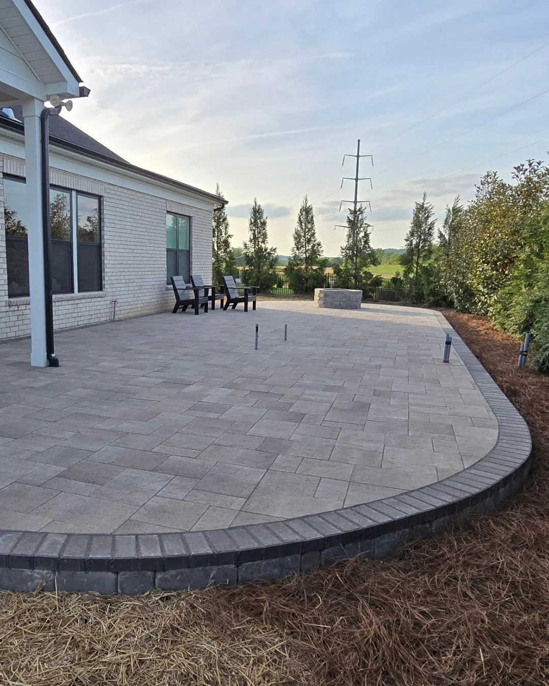 The curved edge of this beautiful patio gives the space a natural flow, the fire pit anchors the zone where the evening actually happens, and the location does the rest with open views, open sky, and exactly the kind of backdrop that turns a Tuesday 