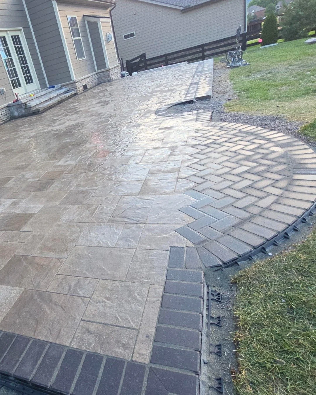The size of a patio is what you notice first. The craftsmanship is what you notice every day after that.

This herringbone inlay set into the larger field pattern isn't just a design choice, it's a test of execution. Getting two patterns to meet clea