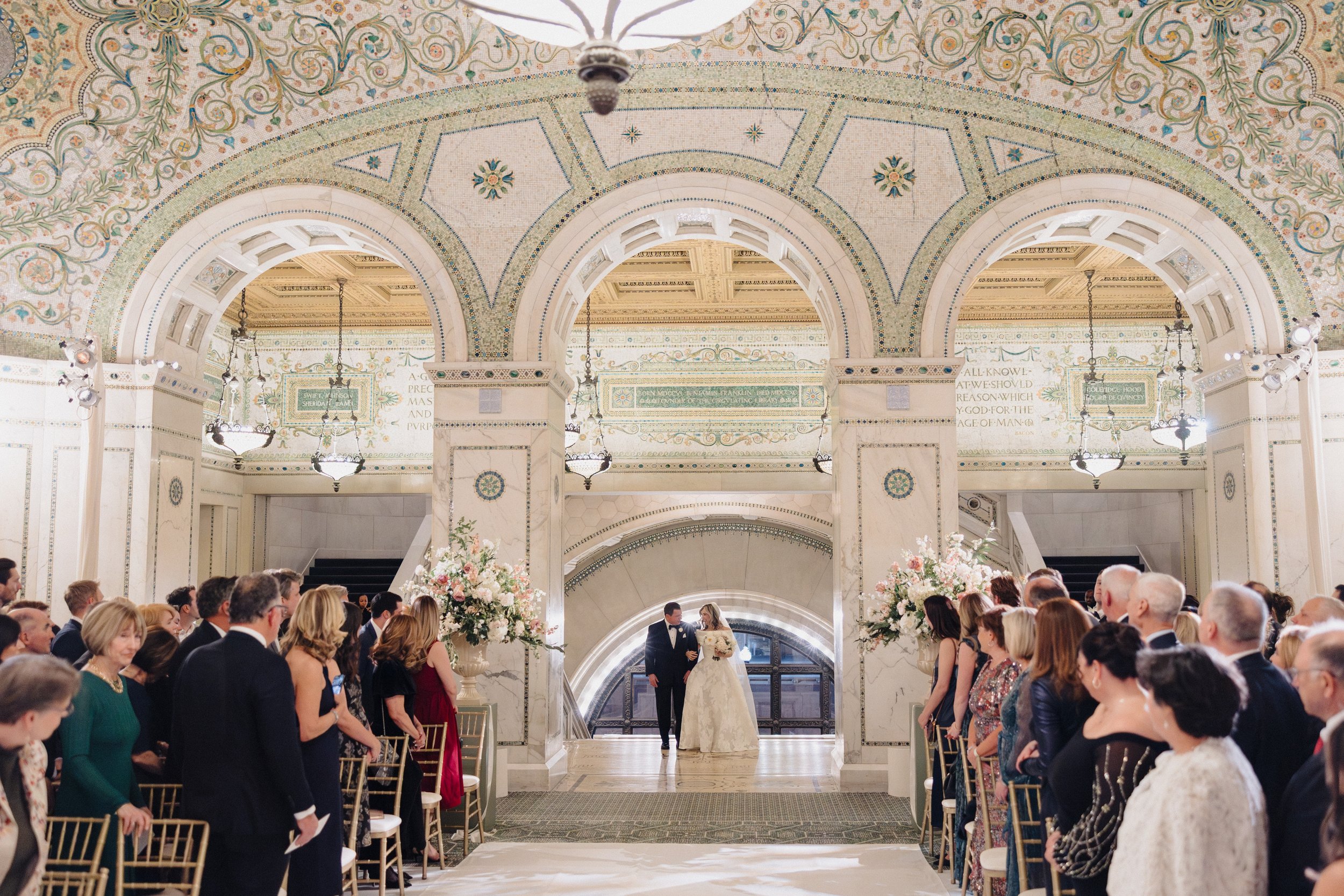 Bride walks down the aisle at wedding ceremony at the Chicago Cultural Center