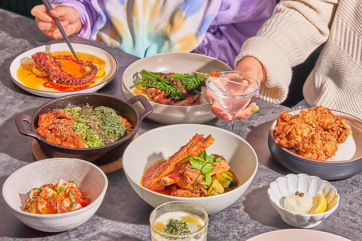 Shared plates at 8282 NYC: Korean fried chicken, braised short rib, grilled octopus, and a cocktail on one table