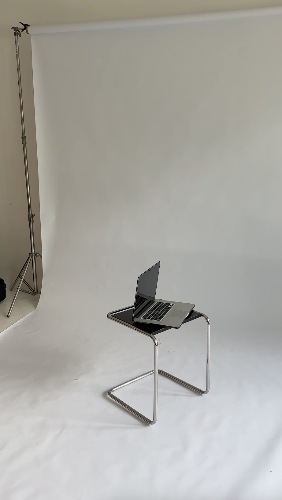 Laptop auf einem Stuhl in einem Foto-Set mit weißem Hintergrund.