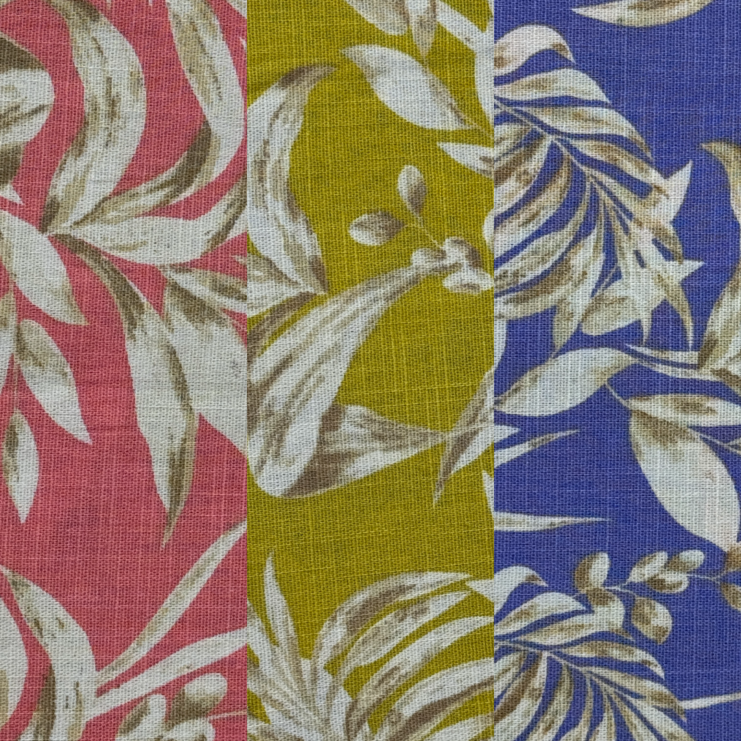Close-up of a multicolored fabric with a floral pattern, featuring red, yellow, and blue sections with white and beige plant designs.
