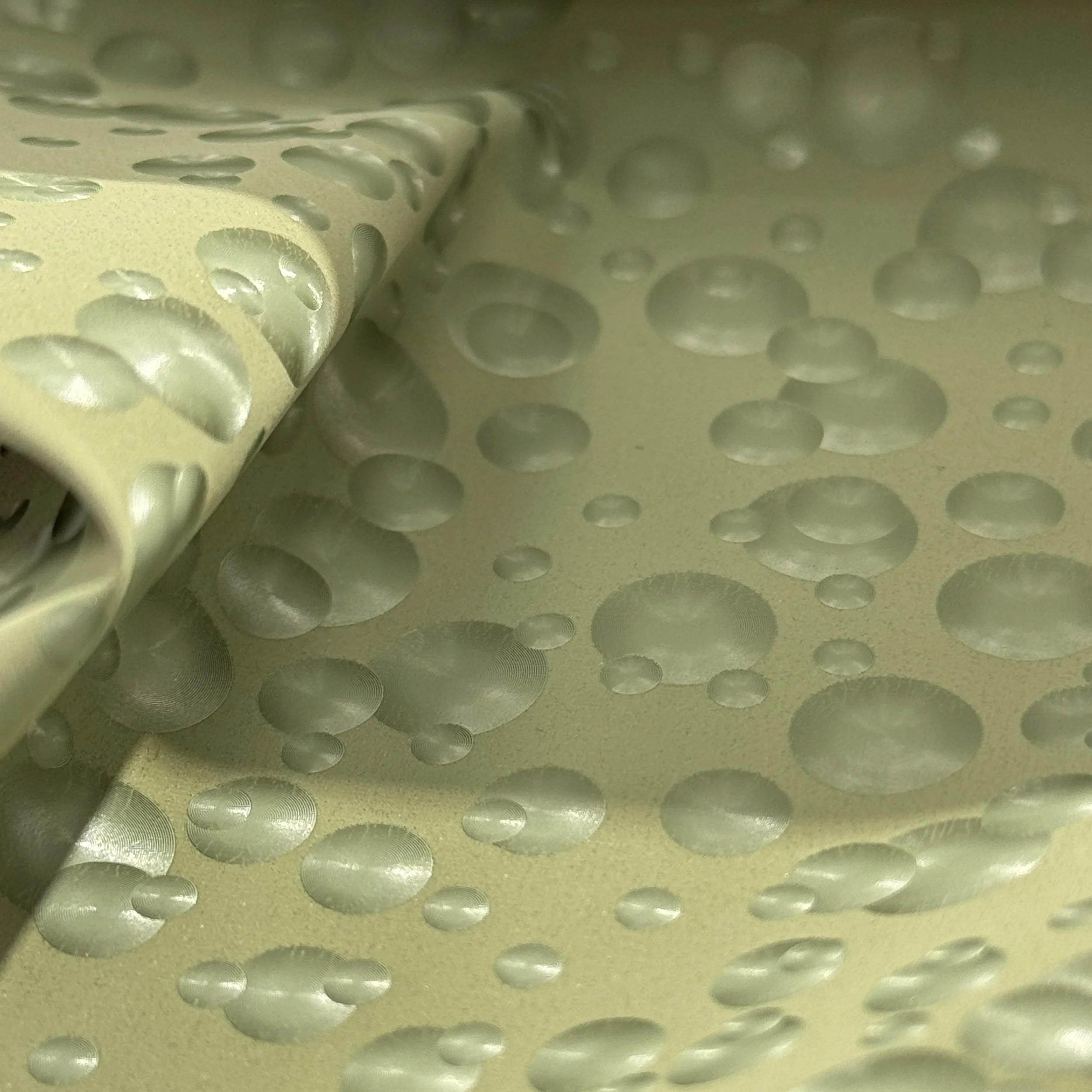 Close-up of a rolled metallic foil sheet with circular indentations.