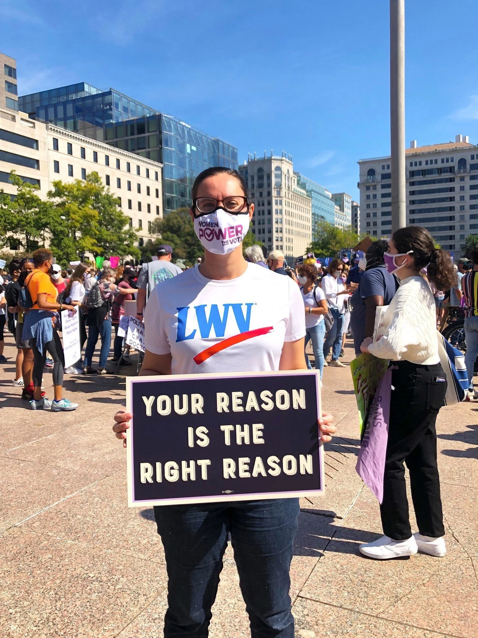 person holding a your reason is the right reason sign