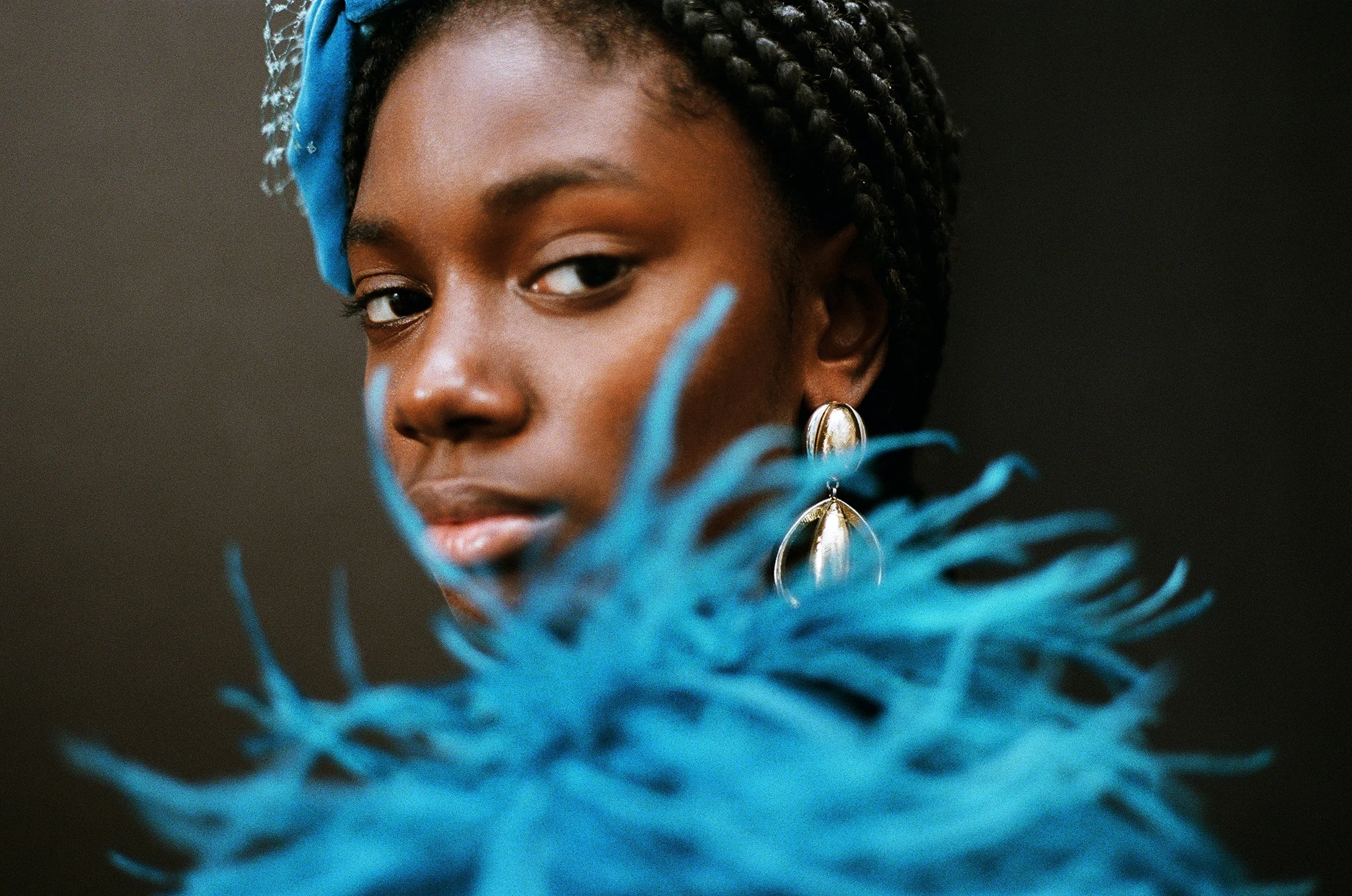 fine jewelry editorial fashion campaign shot by nyc fashion photographer & director duo Indie Studios on film on moody black backdrop with couture feather marchesa dress and bold fashion jewelry inspired by timeless fashion campaigns by Irving Penn