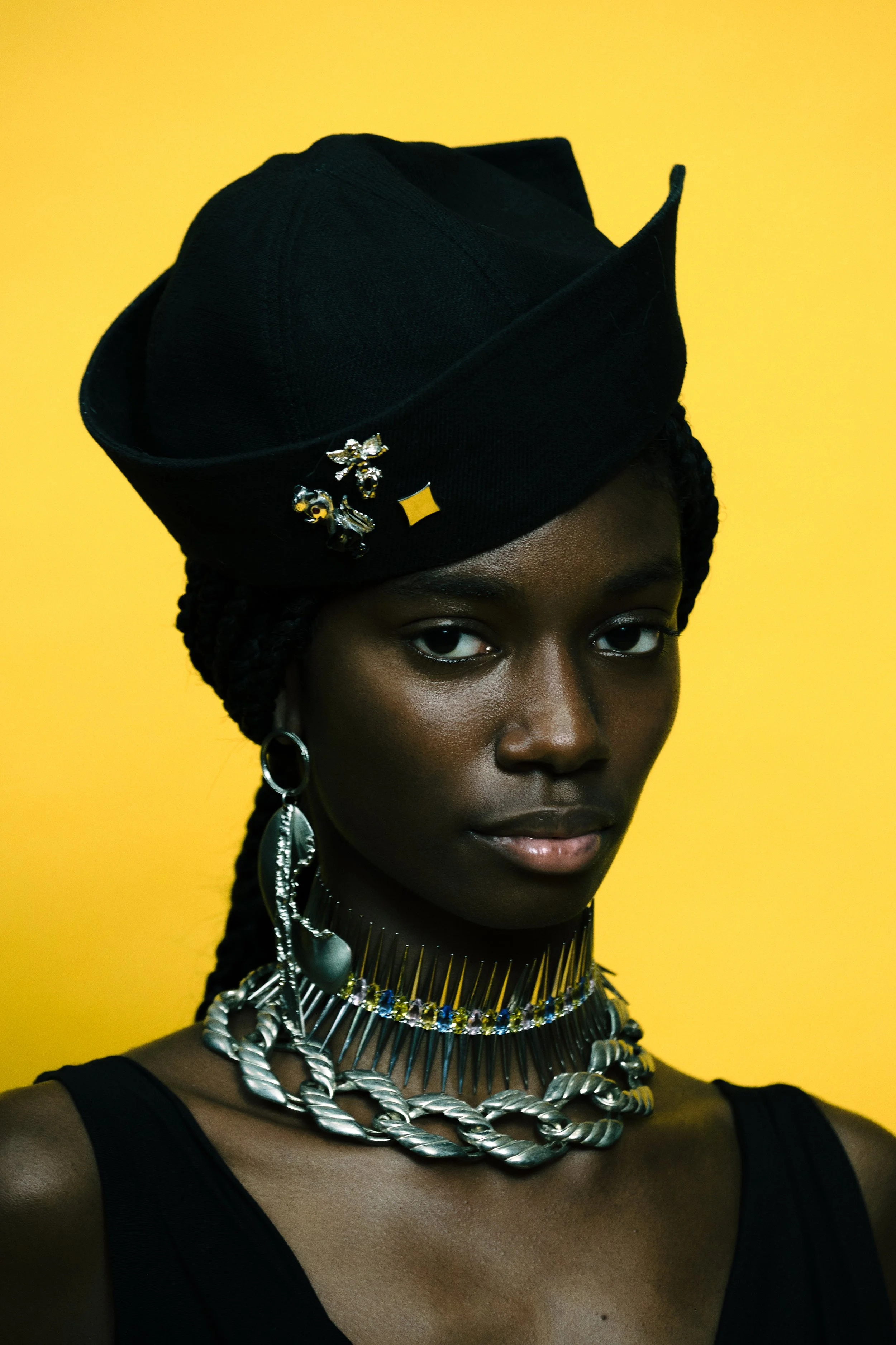 Model Hadiatu poses in colorful studio for nostalgic 90s vogue inspired jewelry campaign  featuring layered fashion jewelry by luxury designers Collina Strada & Vivienne Westwood shot on film by NYC fashion photographer duo Indie Studios.