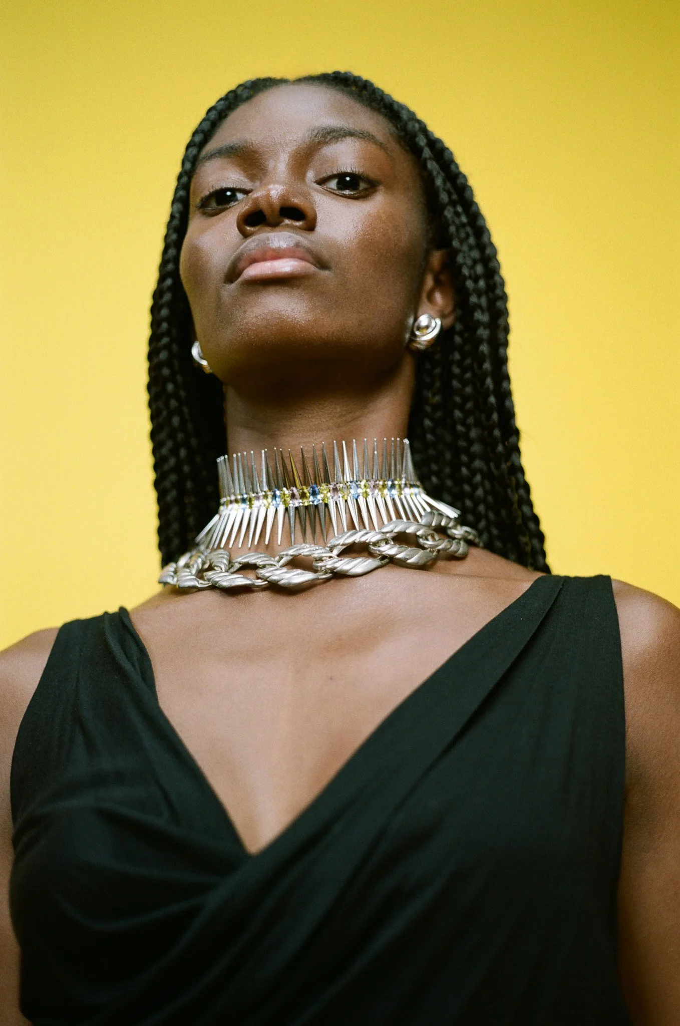 Model wearing collins Strada jewelry and Vivienne Westwood dress with natural braids photographed for editorial jewelry photoshoot by artist couple  Andrew White and Sam Bates in their art studio in New York City