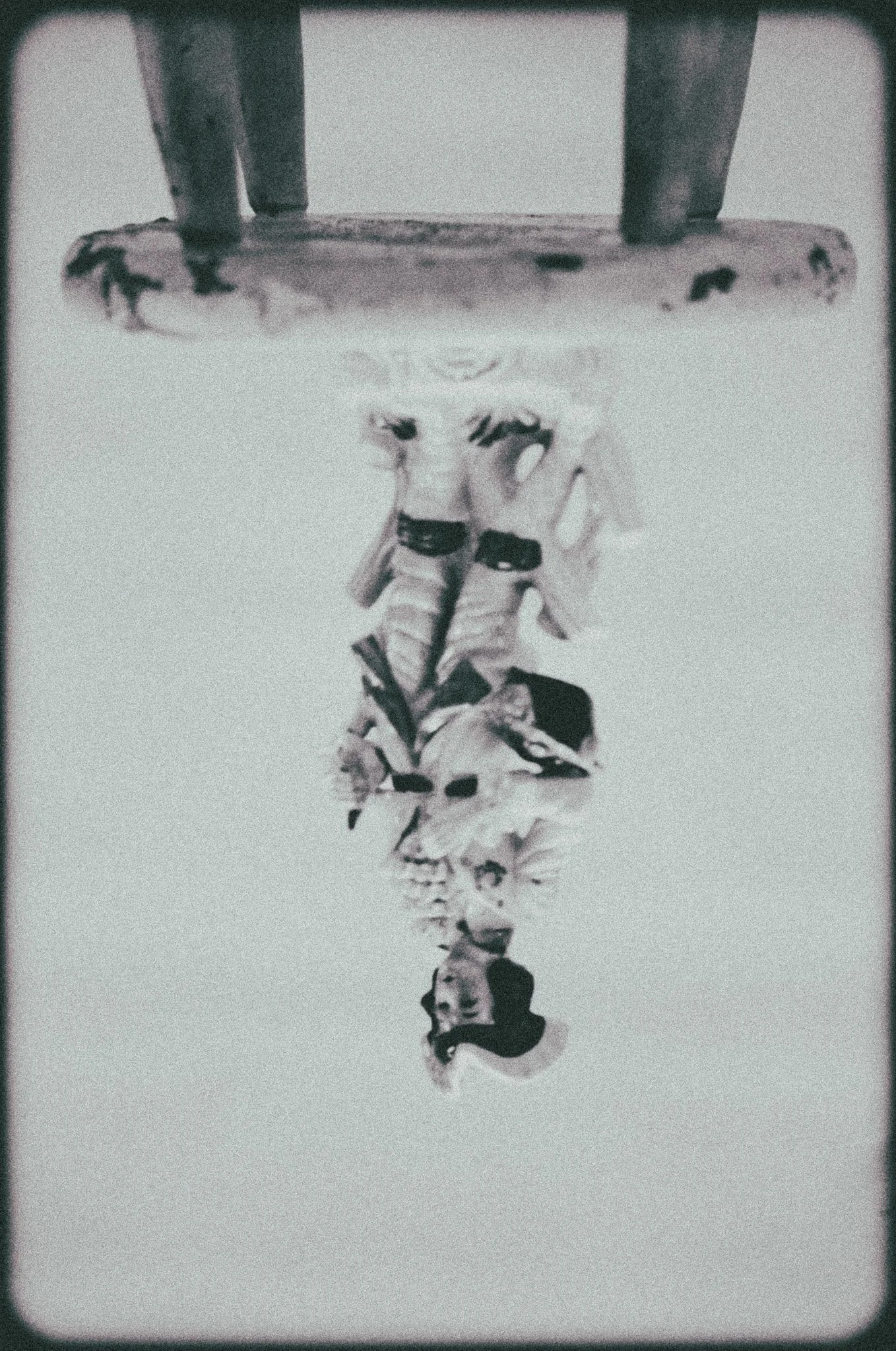 still-life of furniture, an antique sculpture of a victorian man sitting on a white stool, by artist Sam Bates of Indie Studios on black and white film.