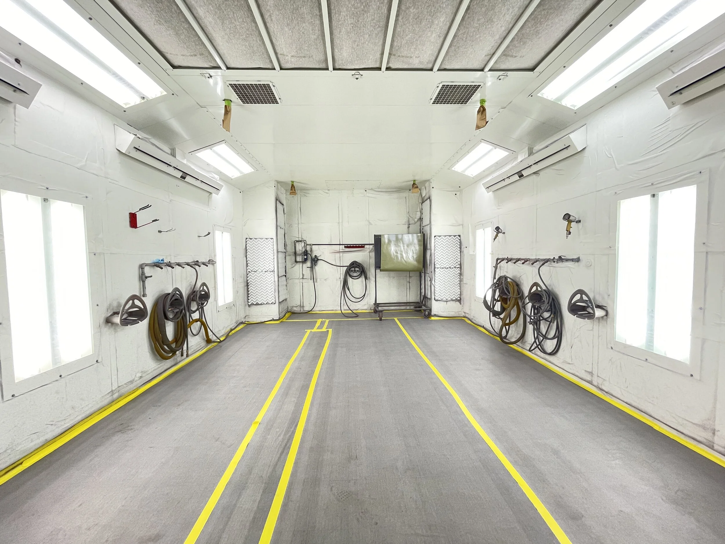 A016 -Dolly in tilt down 
ACTION: Autobody Student spraying colored painted on a fender or car hood