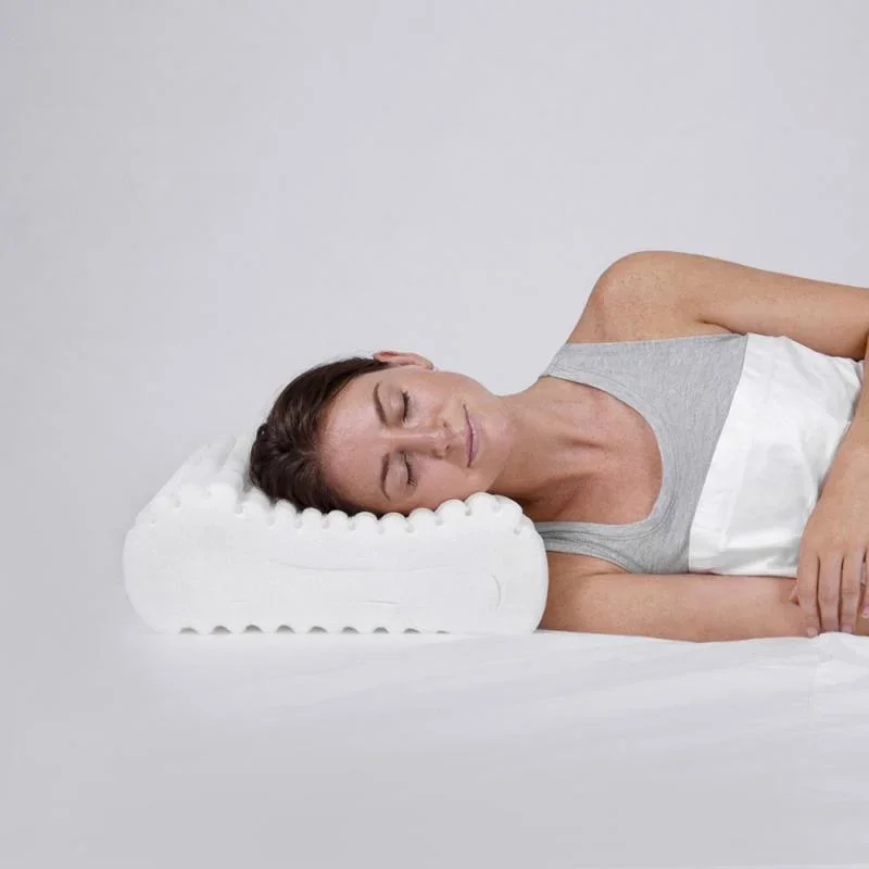 A female in bed on her side with her neck held in correct alignment by her supportive pillow