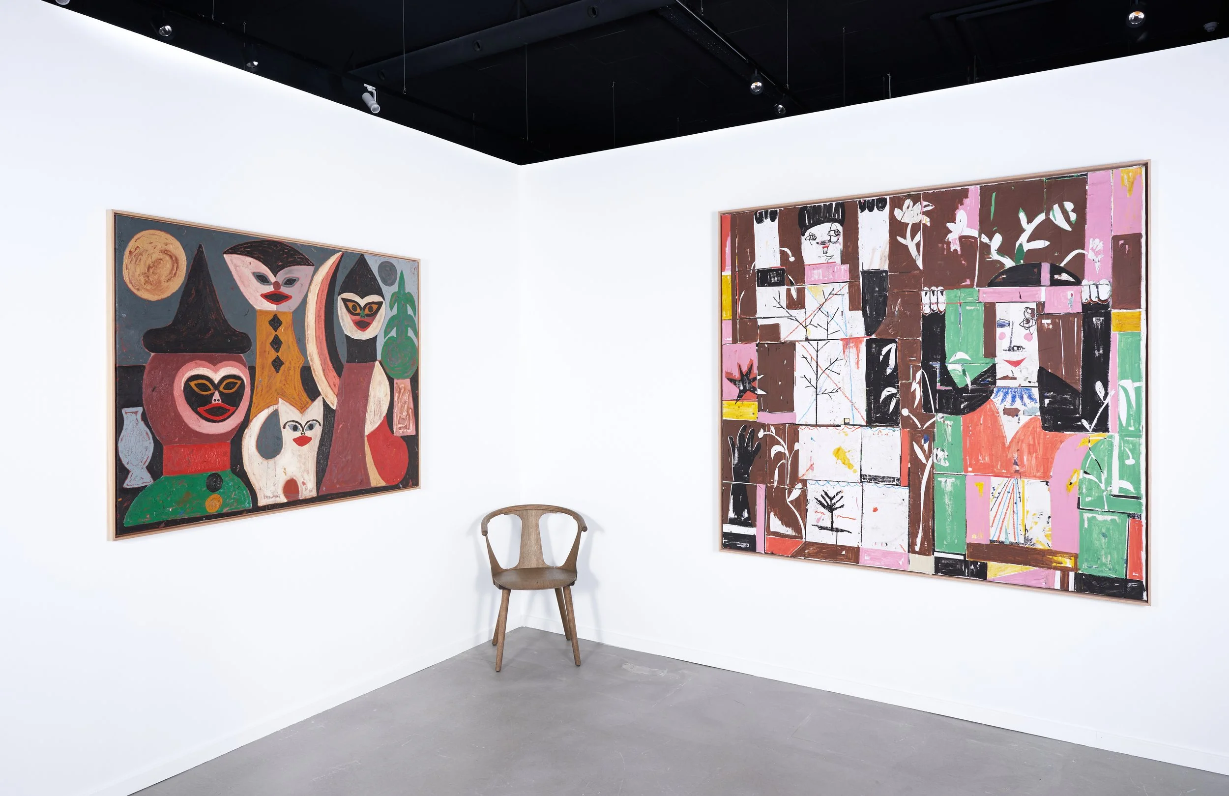 Art gallery with two paintings on white walls, a wooden chair, and gray flooring. The left painting features abstract characters with exaggerated facial features and various colors. The right painting depicts a collage of figures, faces, and abstract shapes in pink, brown, green, black, and white colors.