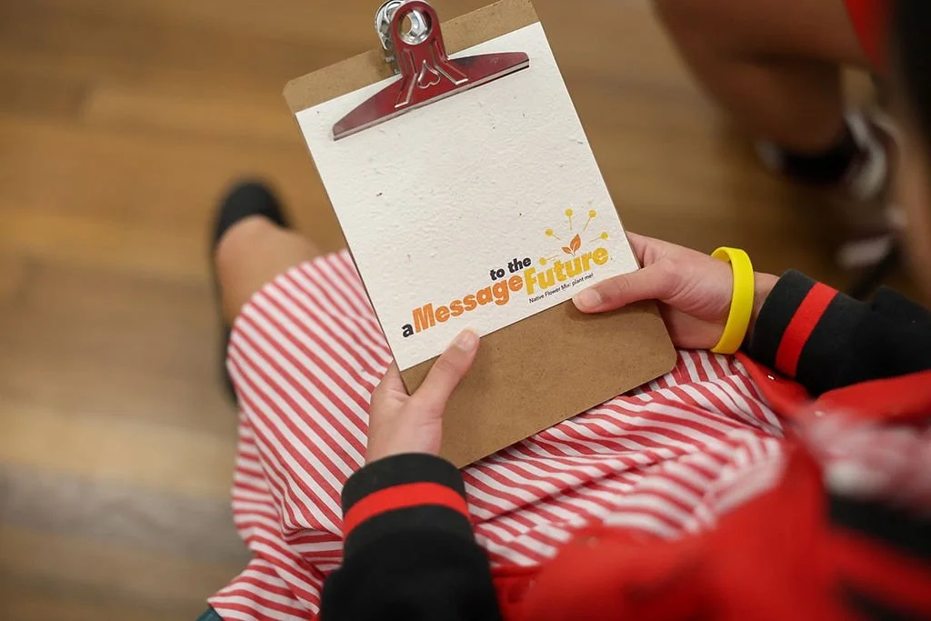 student holding a message to the future seeded card