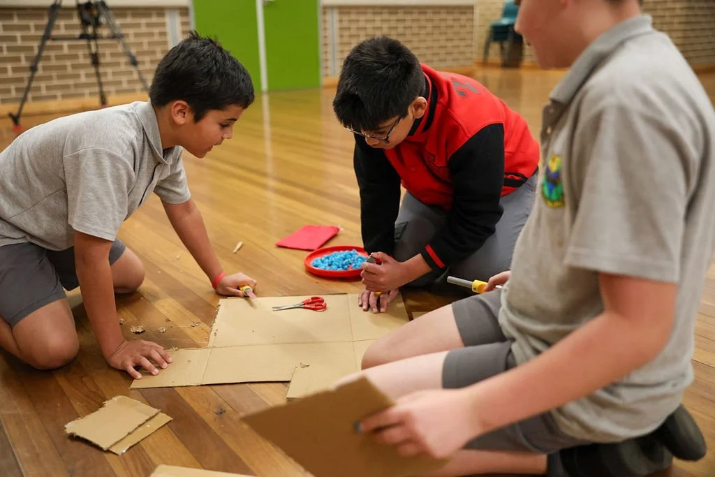 three students creating a cardboard prototype