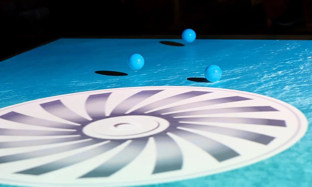 Three blue balls rolling on an interactive projection