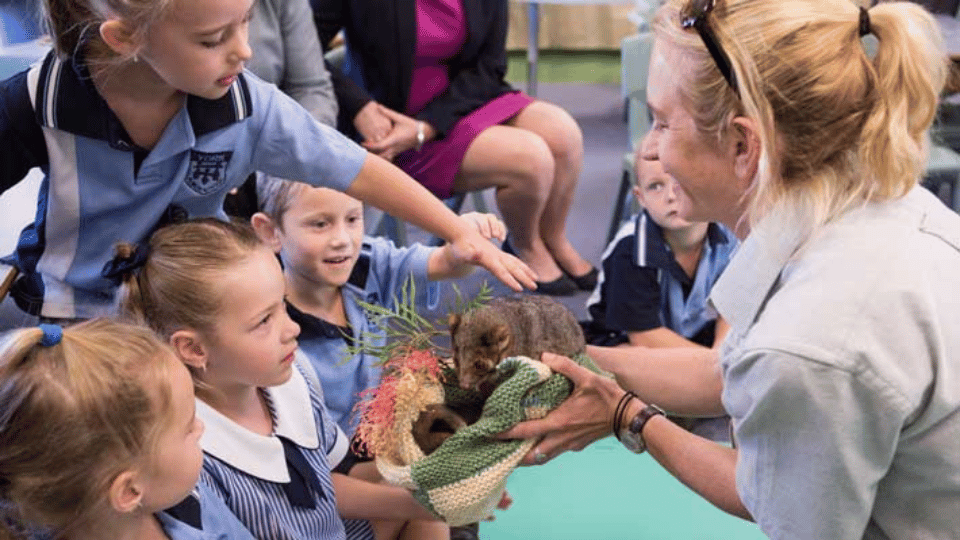 Children and educator with possum