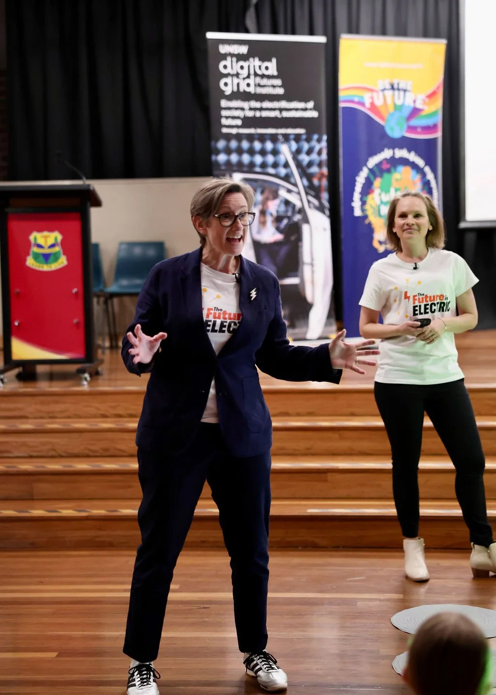 Dr Becky and Sally presenting to the students in front of signage