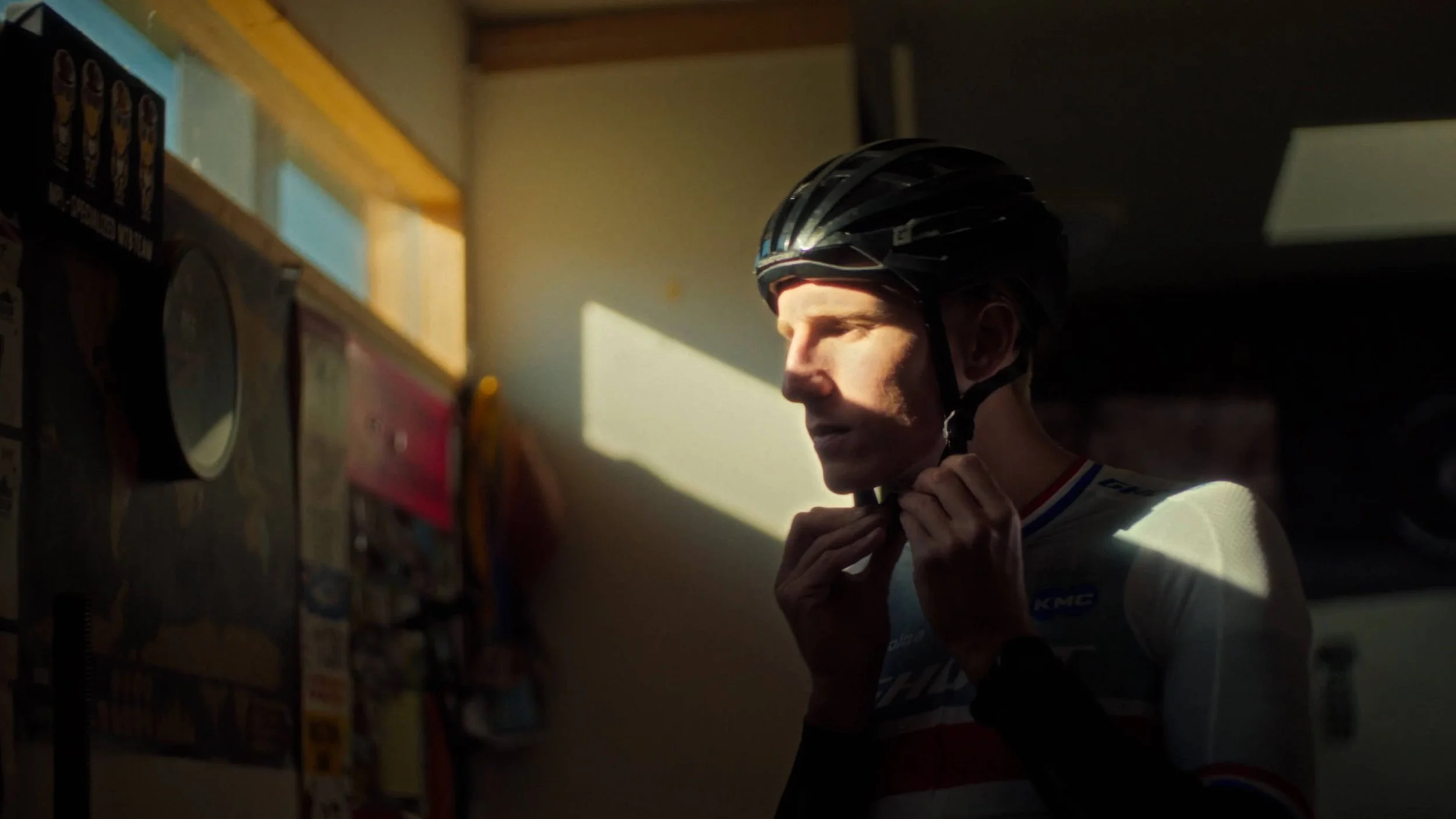 Man die een fietshelm oplegt in een hal met gekleurde posters.