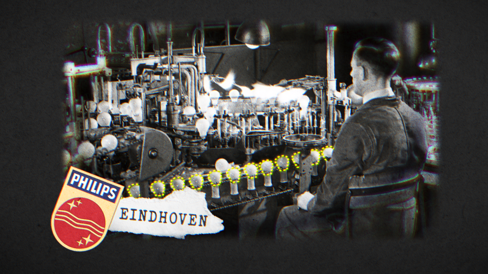 Een foto van een man die aan een vuurwerkmachine werkt. Op de machine zitten veel gloeilampen en metalen onderdelen. Een bordje met de tekst "EINDHOVEN" en een logo met de vlag van China is zichtbaar op de onderste linkerhoek.