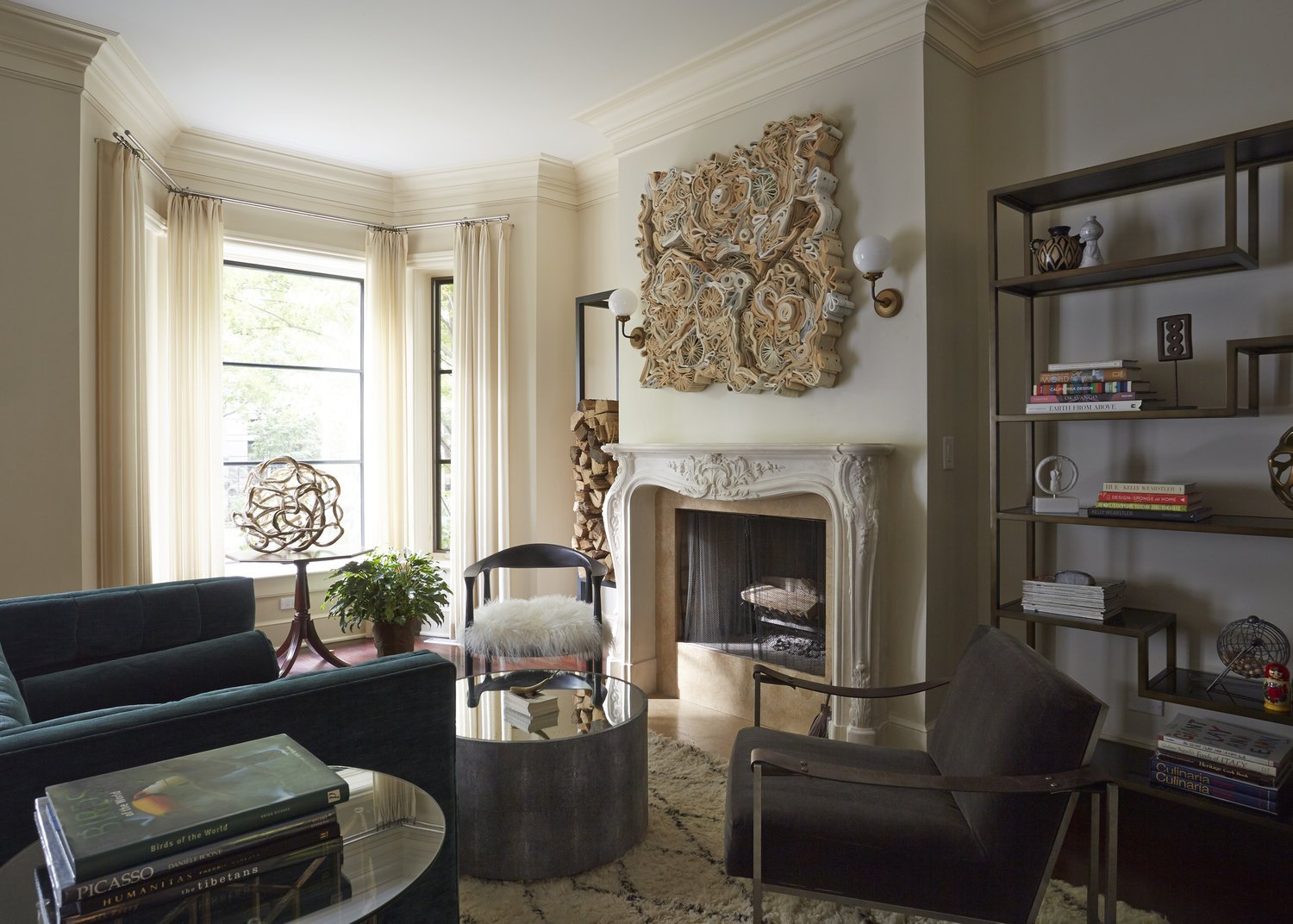 A bright, luxury living room with a curved grey sofa, marble fireplace, and floor-to-ceiling windows, showcasing a modern sophisticated personal style