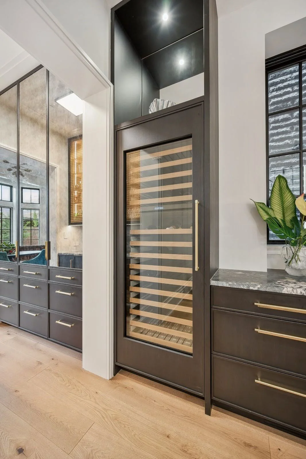 Modern kitchen with a seamlessly integrated built-in wine fridge and custom dark cabinetry at the Lincoln Park Wonderland project.