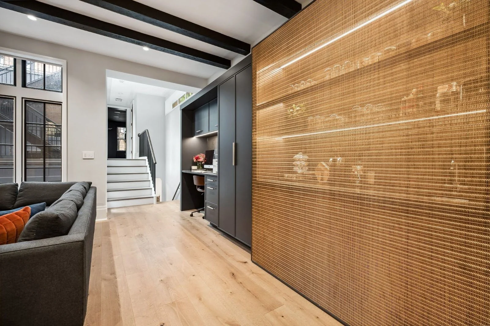 A custom convertible study space in Lincoln Park featuring a metal mesh door that slides to hide a desk and reveal a coffee bar.