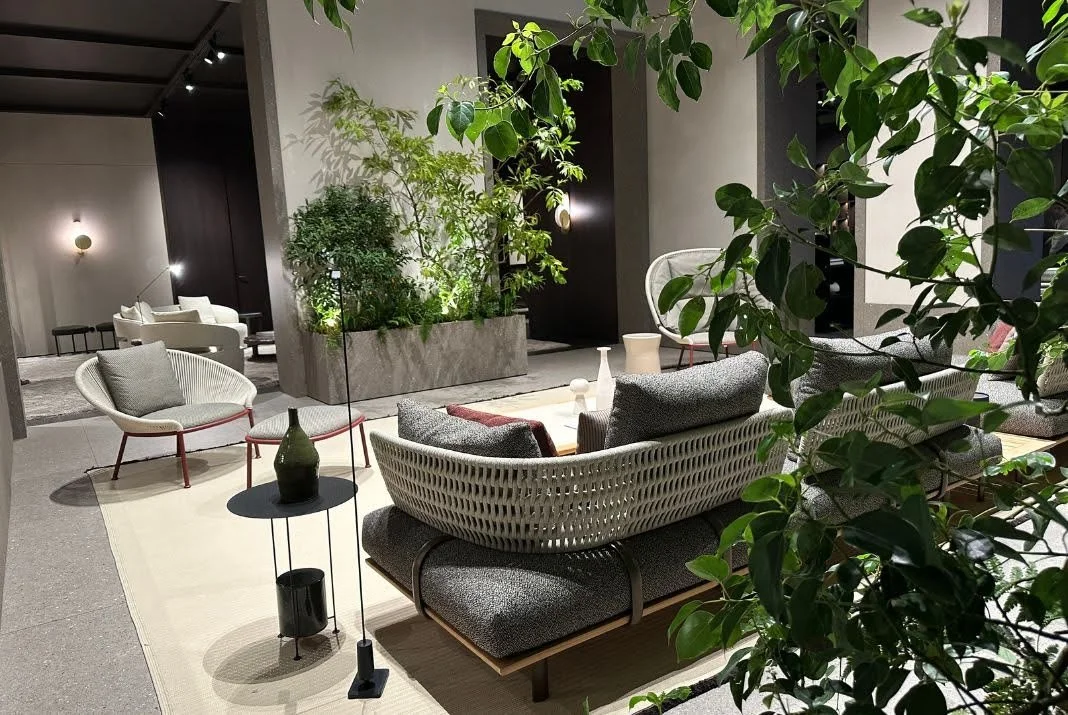 Indoor lounge area integrated with lush green plants and natural stone textures, illustrating the 2025 biophilic design trend