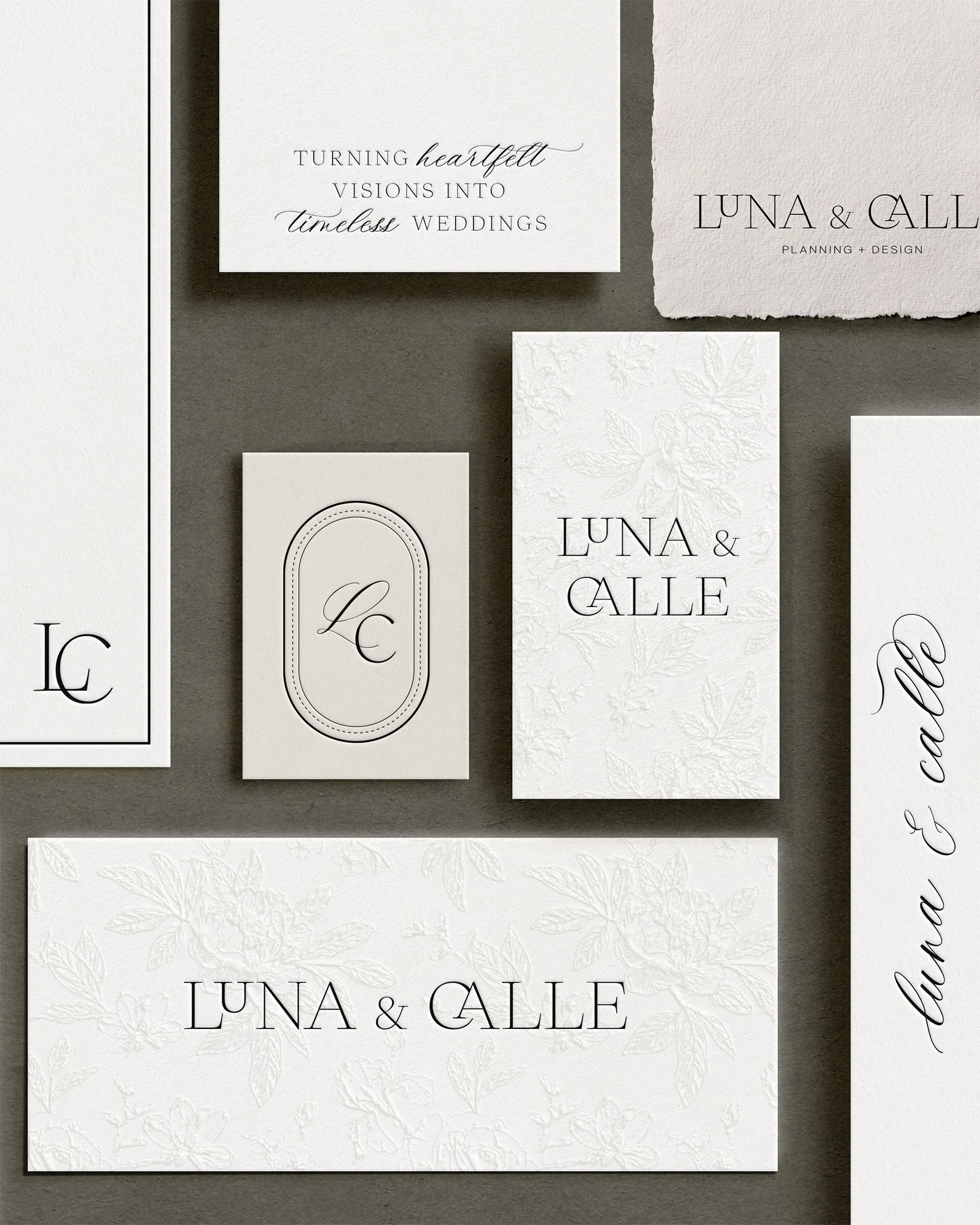 Collection of wedding stationery including invitations and cards with text such as "Luna & Calle" and phrases about turning heartfelt visions into timeless weddings, laid out on a dark gray background.