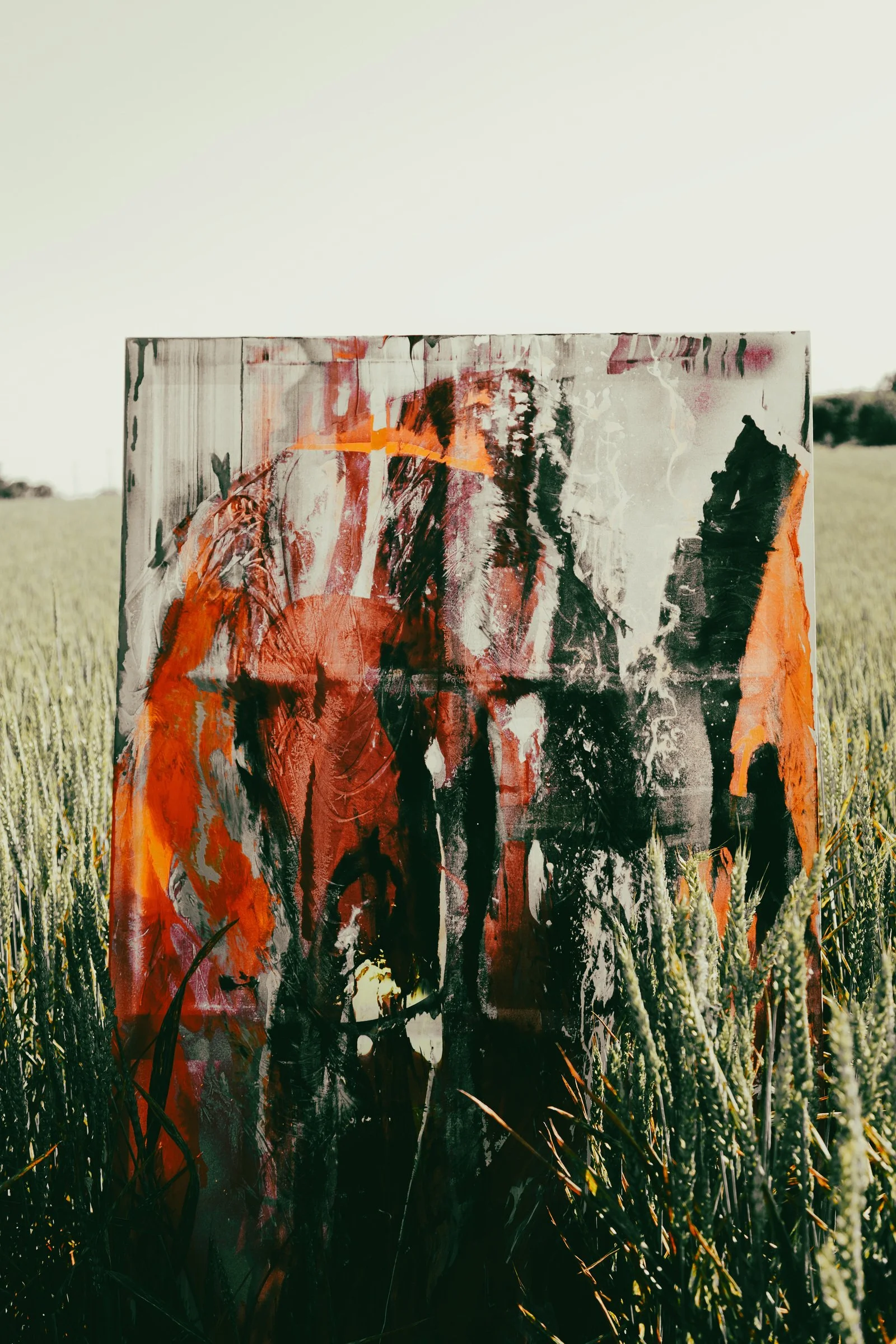 Une peinture de GUNFLAMM posée au milieu d’un champ de blé.