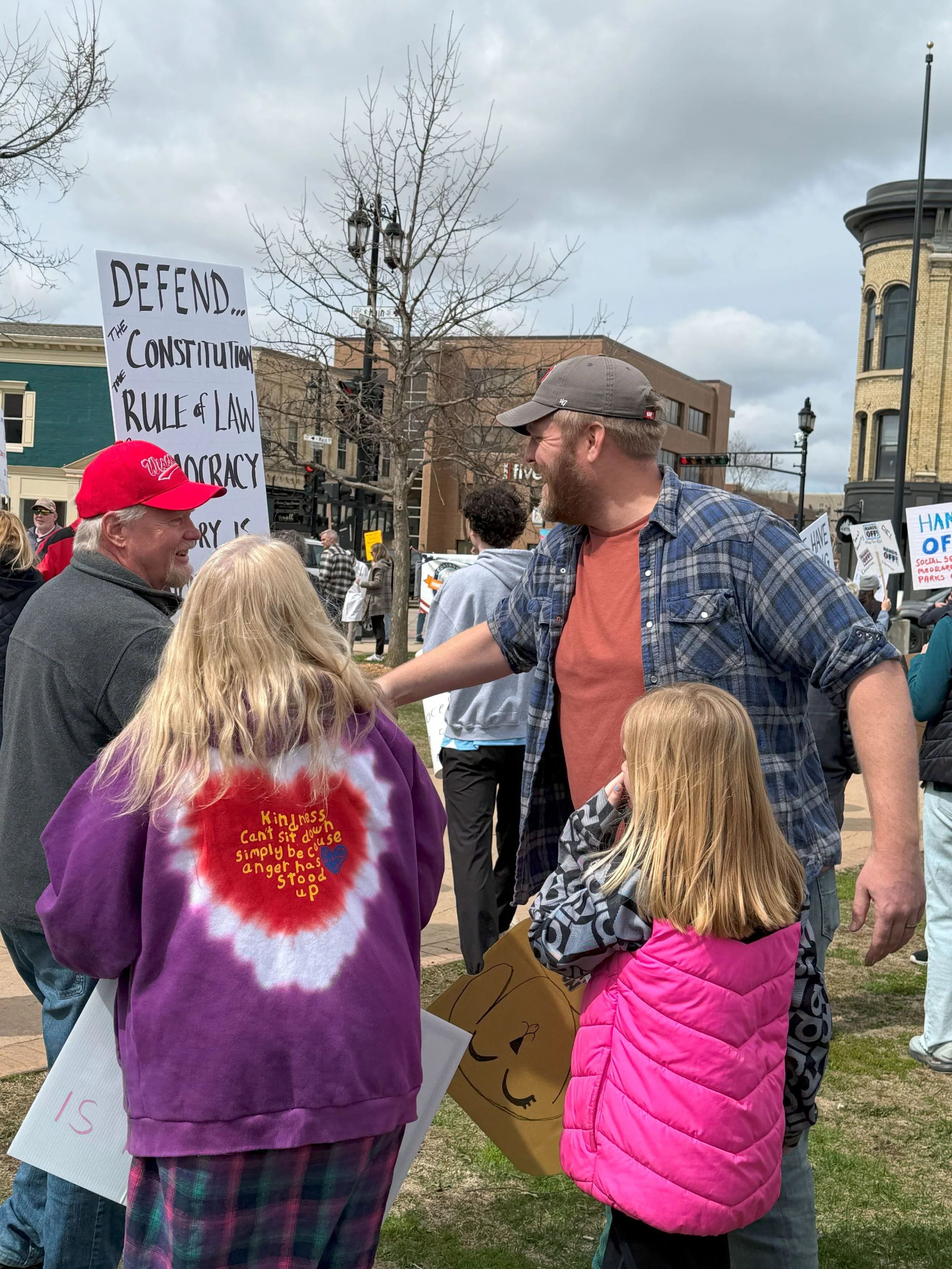 Mike Van Someren shakes hands with fellow protestors at No Kings protest in Oconomowoc.
