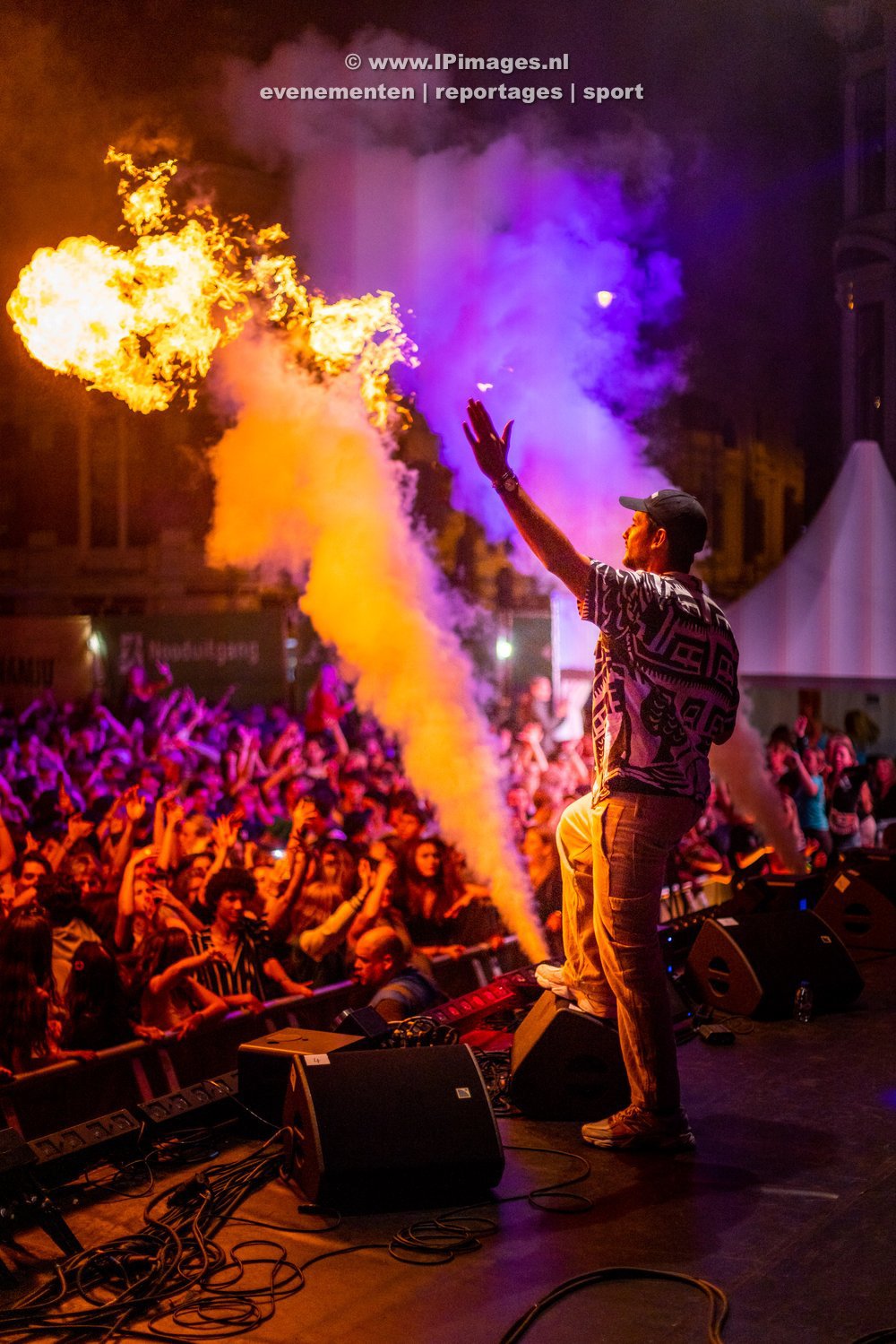 Festivalfoto van het optreden van Kris Kros Amsterdam met FeestDJ Ruud op het Haarlem Jazz Festival op de Grote Markt, met een spectaculaire pyroshow en de Sint-Bavokerk op de achtergrond, vastgelegd in levendige kleuren en dynamische compositie. Gem