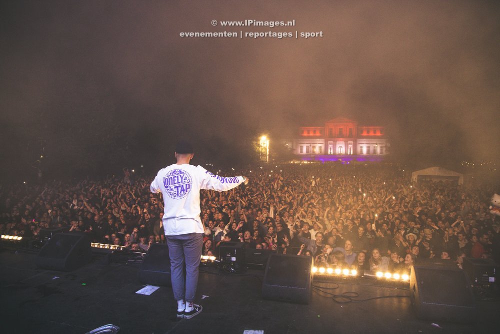 Festivalfoto van het optreden van Kris Kros Amsterdam op het Haarlem Jazz Festival op de Grote Markt, met een spectaculaire pyroshow en de Sint-Bavokerk op de achtergrond, vastgelegd in levendige kleuren en dynamische compositie. Gemaakt door fotogra