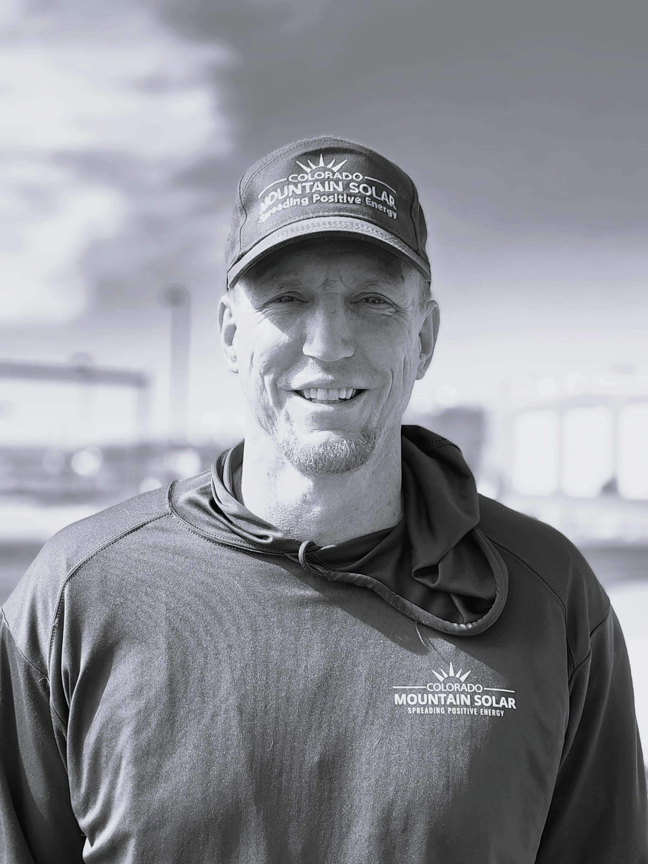 A smiling man with facial hair wearing a cap that reads 'Colorado Solar Energy' in black and white.