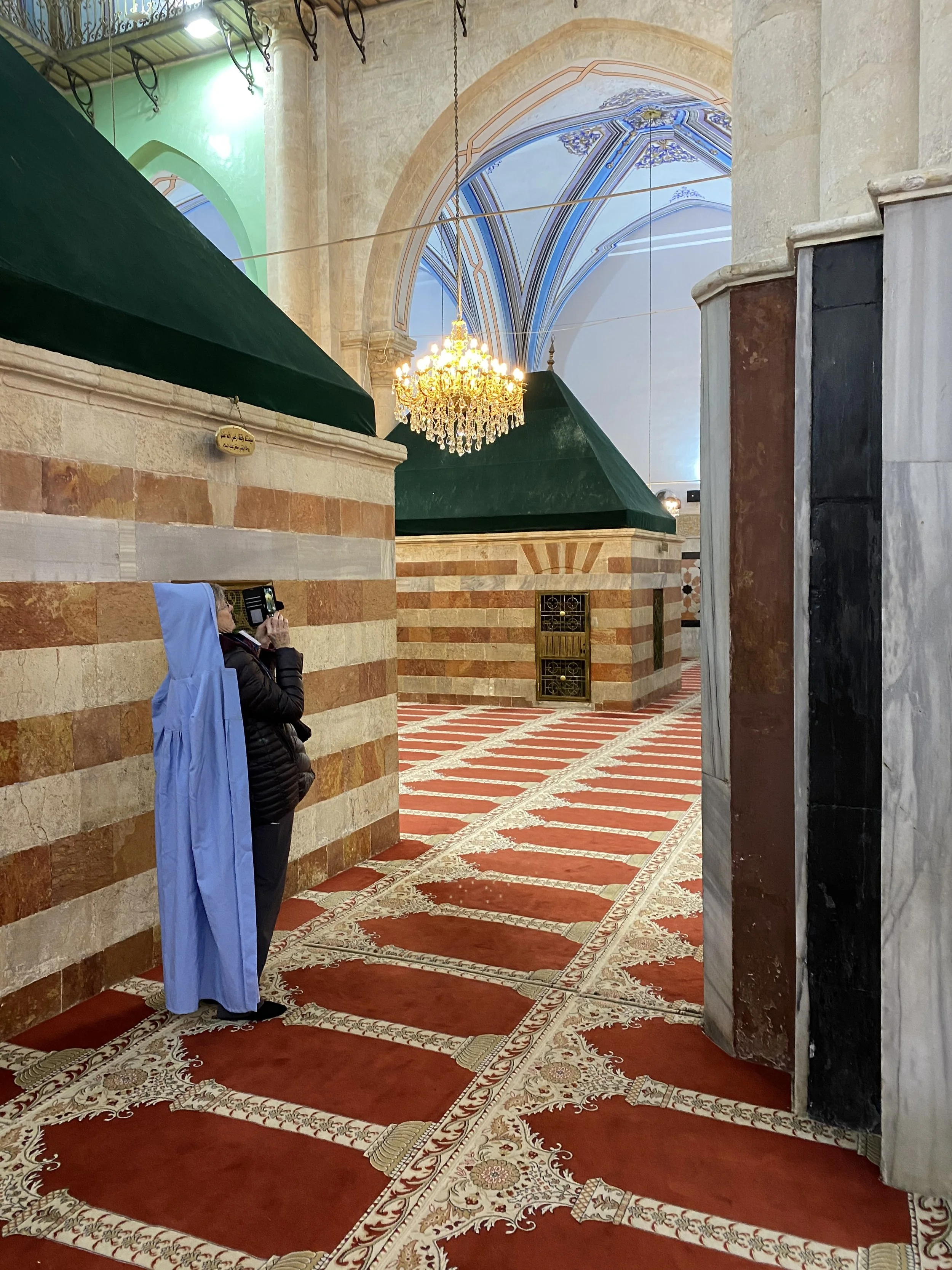 entering the Mosque.  The women in the group were given hooded garments to put over their clothes and head.  The brick enclosures cover the cenotaphs of Isaac and Rebekah