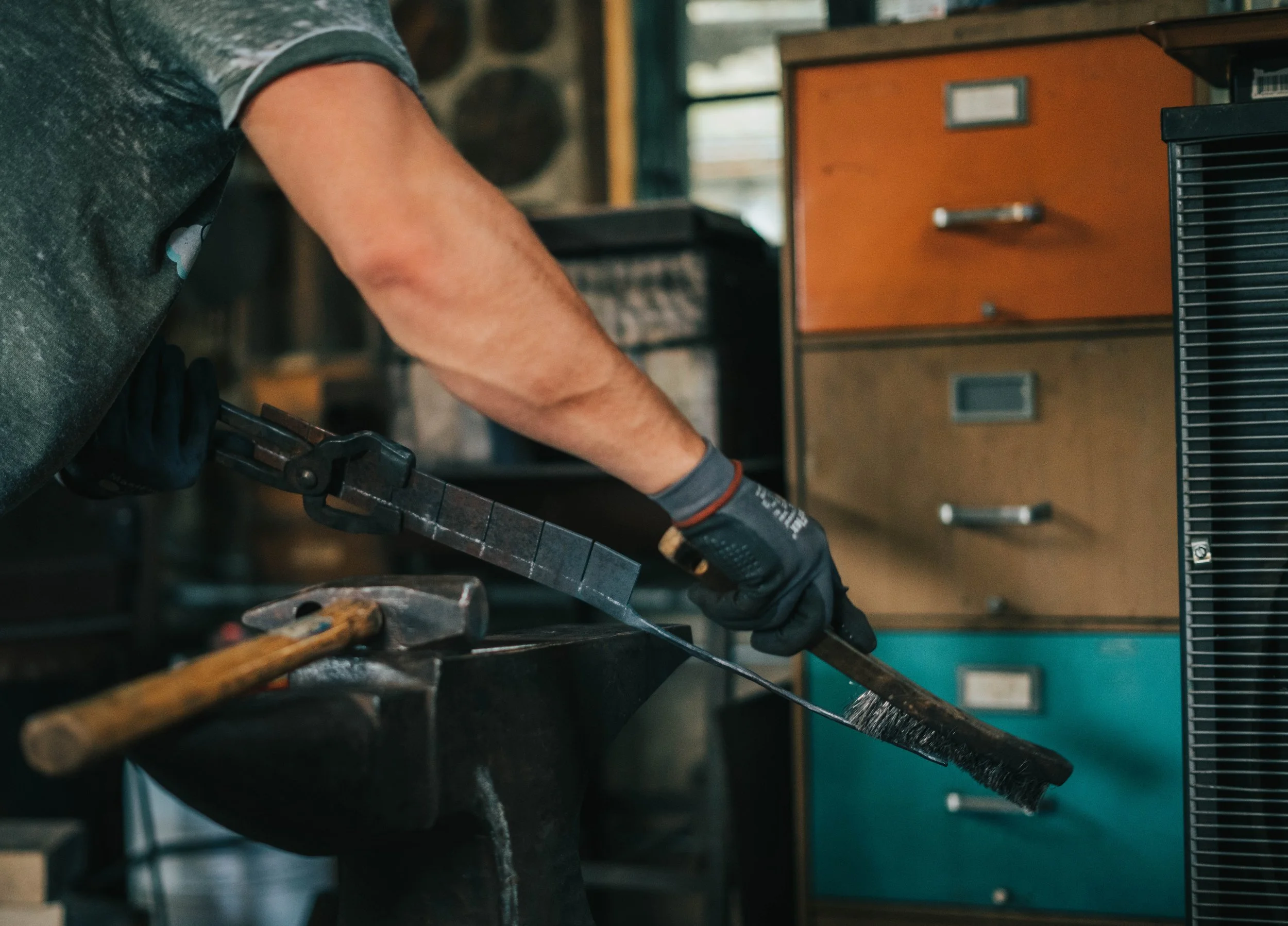 Tim Kinsey using a standard wire brush to knock off any loose steal. He is working on the stem on a soon-to-be rose.
