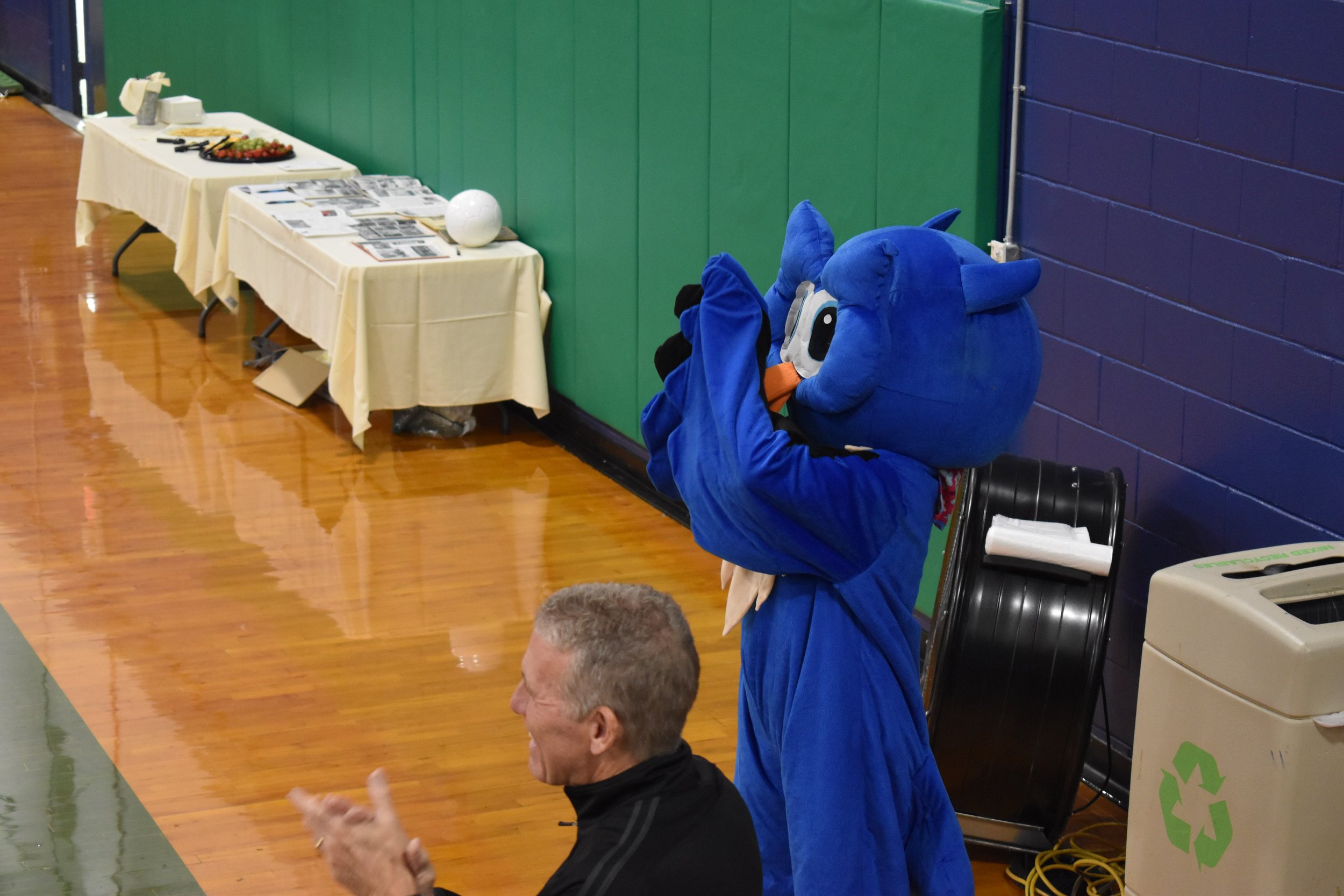  Owl mascot clapping during field dedication ceremony moved to Devries due to rain. 