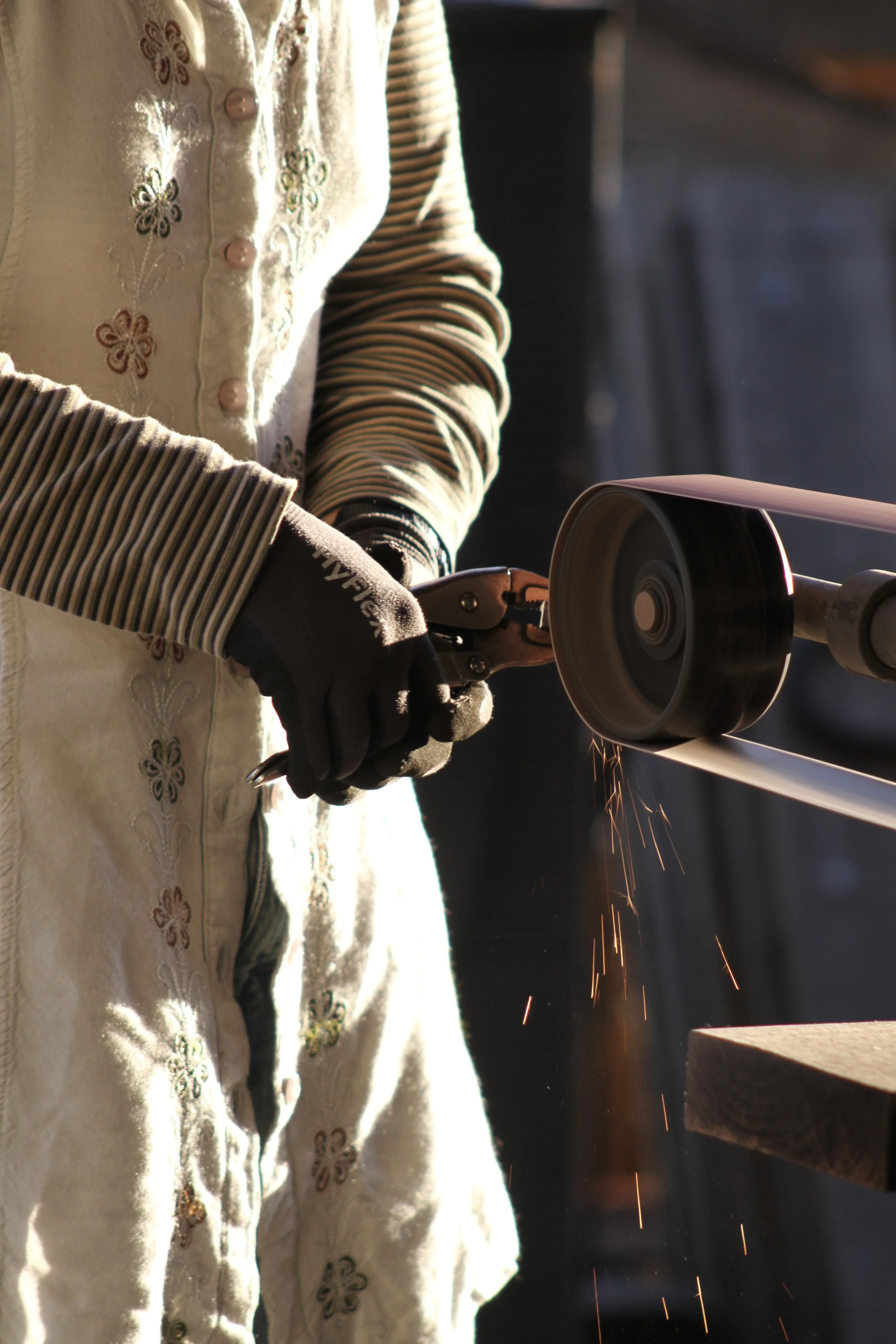  Sophomore  Merritt Yoder  smooths out a punch ring on a belt sander, the final step in the process, outside the forge on Nov. 4, 2025, in Swannanoa, N.C. 