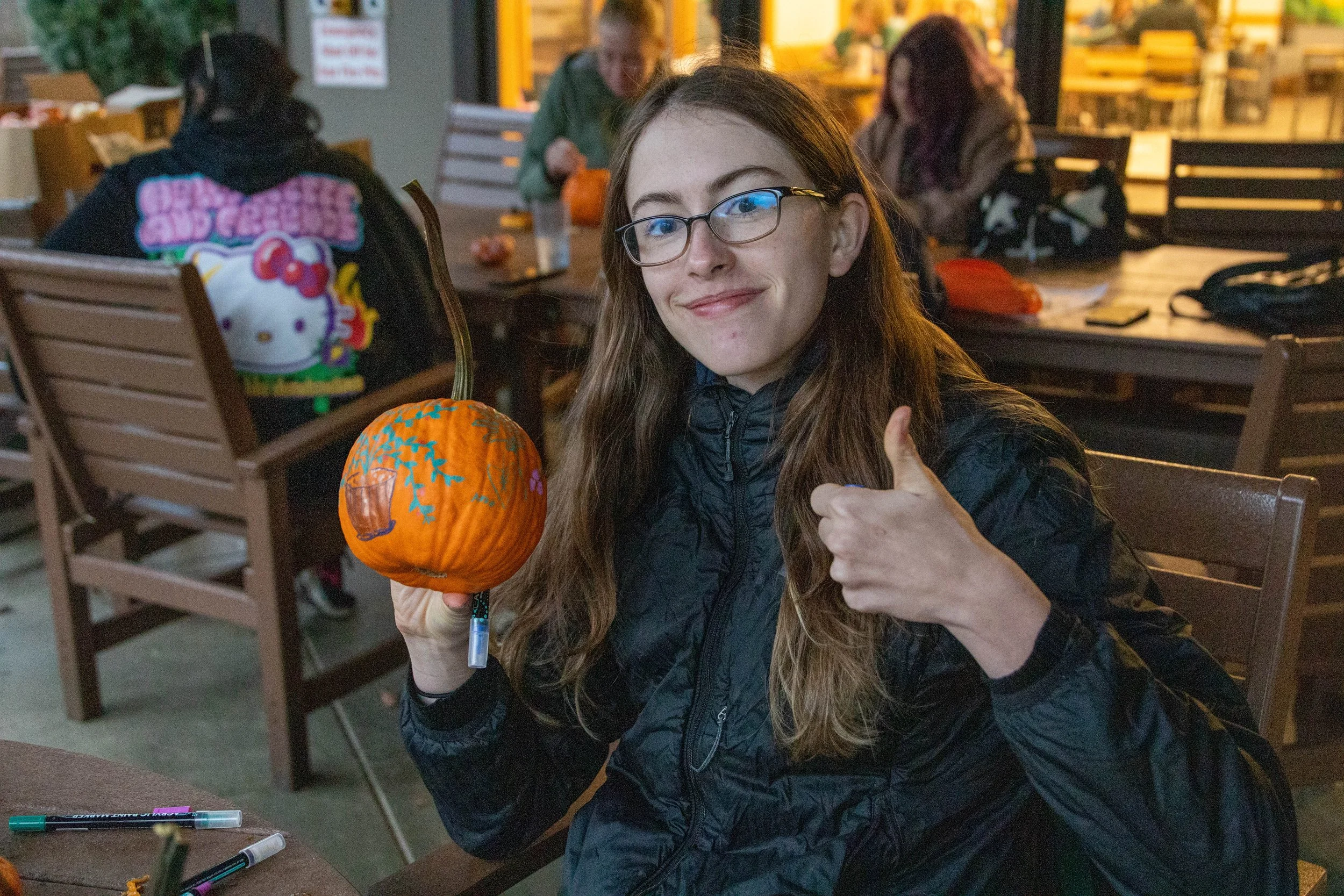  A Warren Wilson College (WWC) student smiles and displays a pumpkin at a pumpkin carving event on October 30, 2025 in Swannanoa, N.C. (Neko Heinrich) 