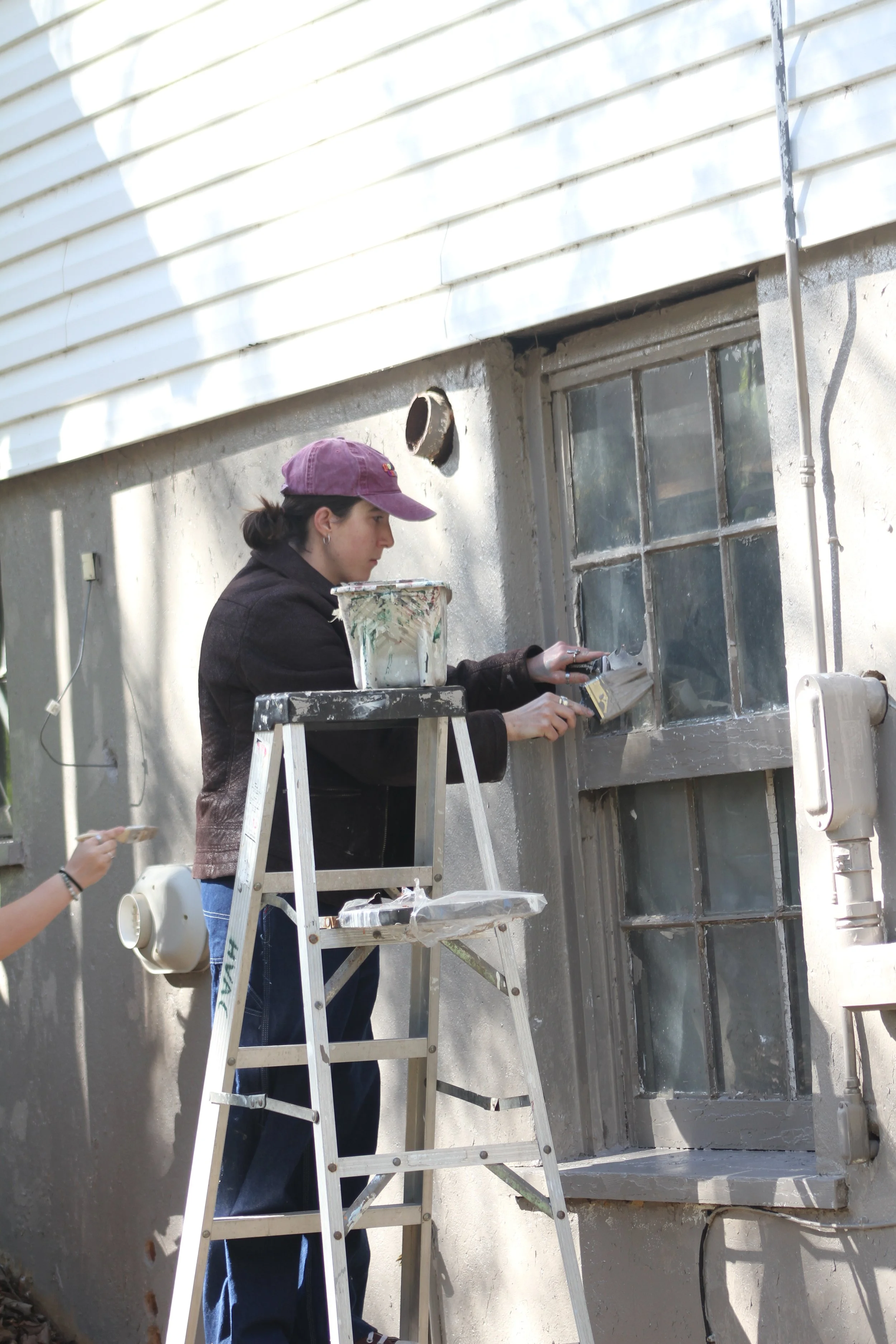 Students paint the St. Clair Guest House at Warren Wilson College (WWC) on Thursday, April 9, in Swannanoa, N.C. (Echo/Vivian Bryan)