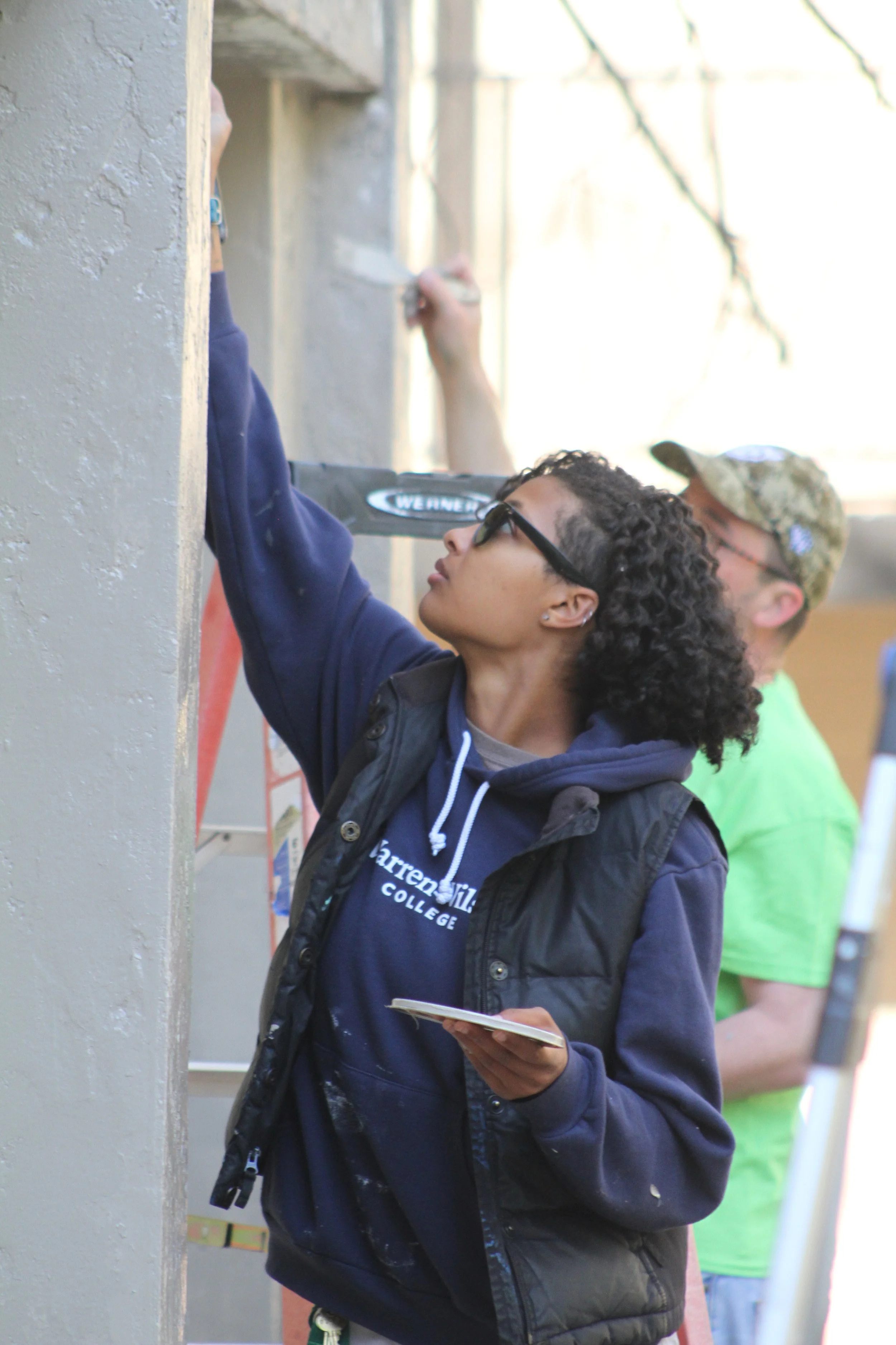Students paint the St. Clair Guest House at Warren Wilson College (WWC) on Thursday, April 9, in Swannanoa, N.C. (Echo/Vivian Bryan)