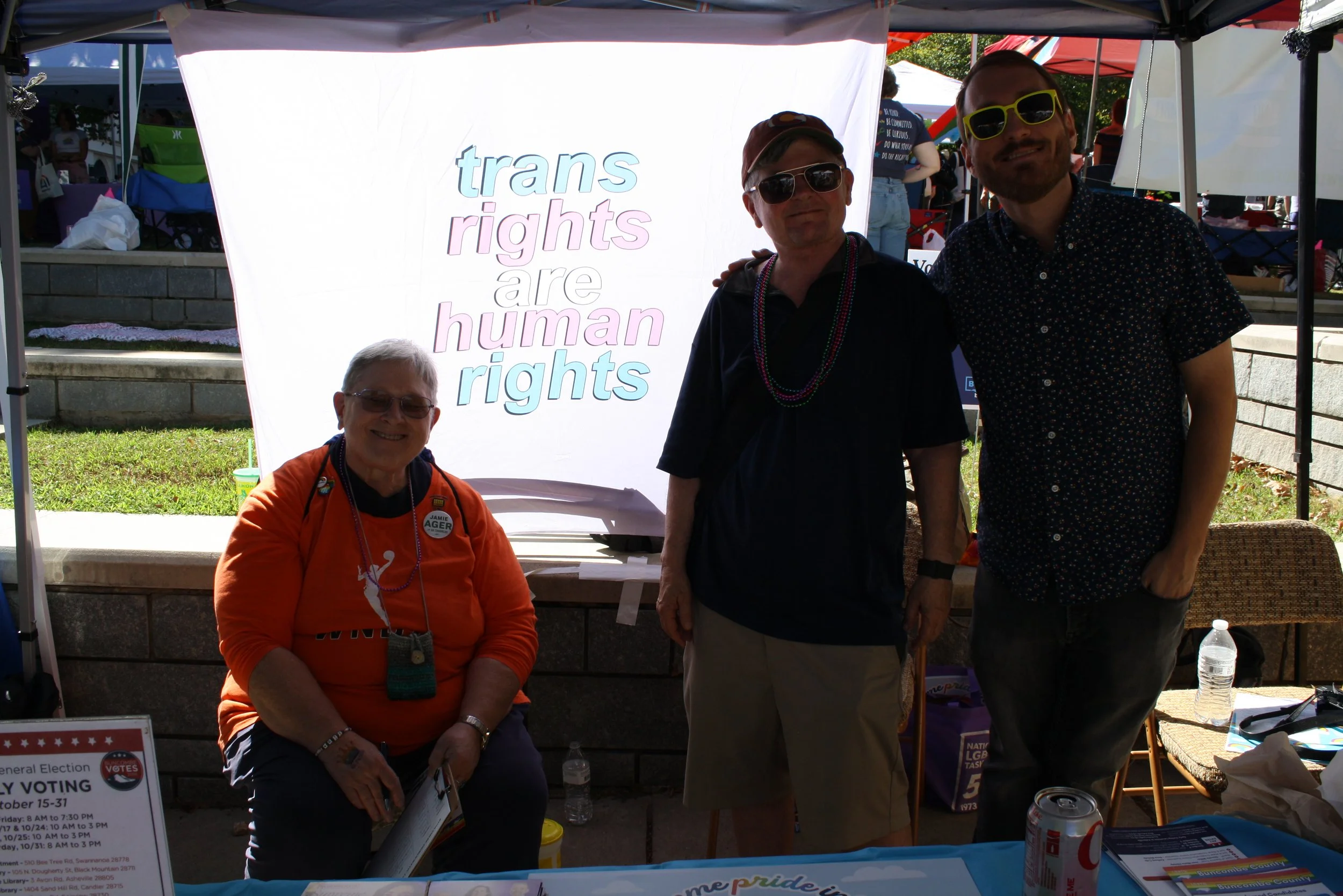  Volunteers including Warren Wilson College alumna Elaine Ferguson ‘78 (left) in front of a banner reading “trans rights are human rights” at Blue Ridge Pride on Sep. 26, 2026 in Pack Square Park in Asheville, N.C. (Echo/Emma Taylor McCallum) 