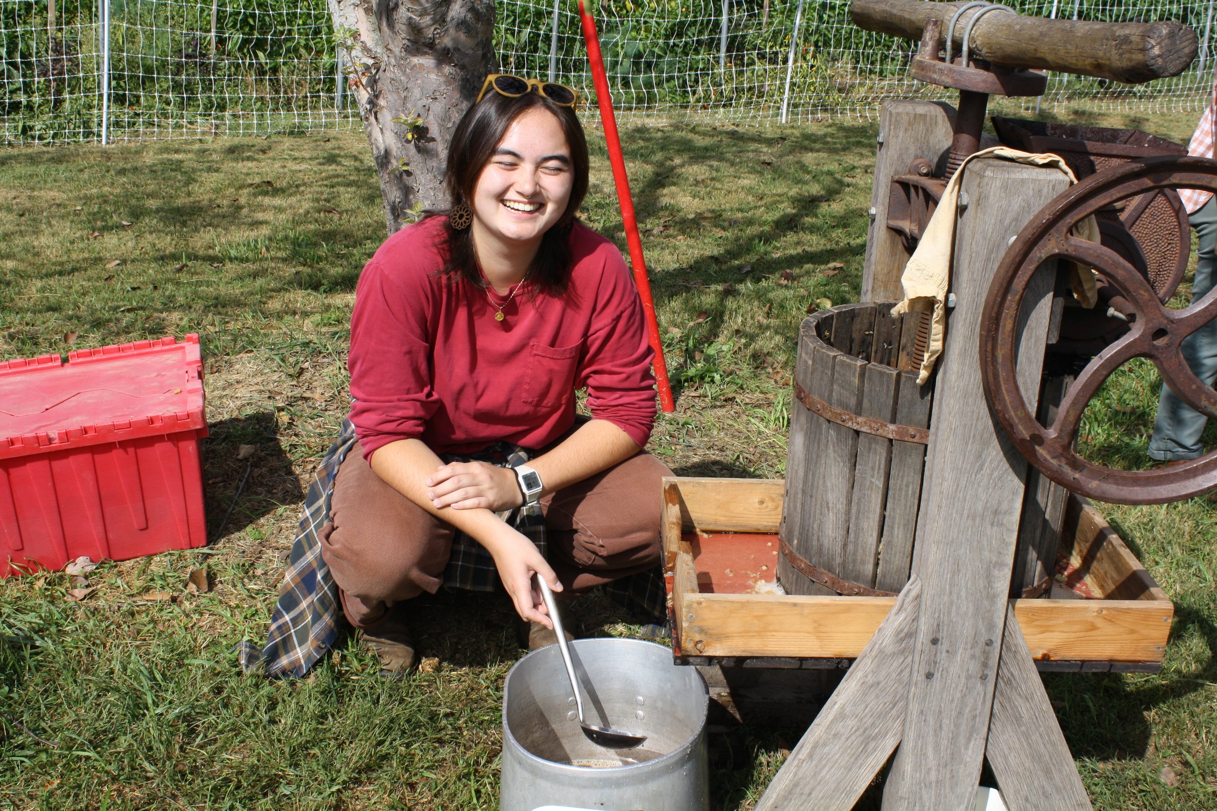  Garden Crew member Thi Hyunh sits while pressing apple cider at Warren Wilson College’s Fall Festival on Oct. 3, 2026 in Swannanoa, N.C. (Echo/Emma Taylor McCallum) 