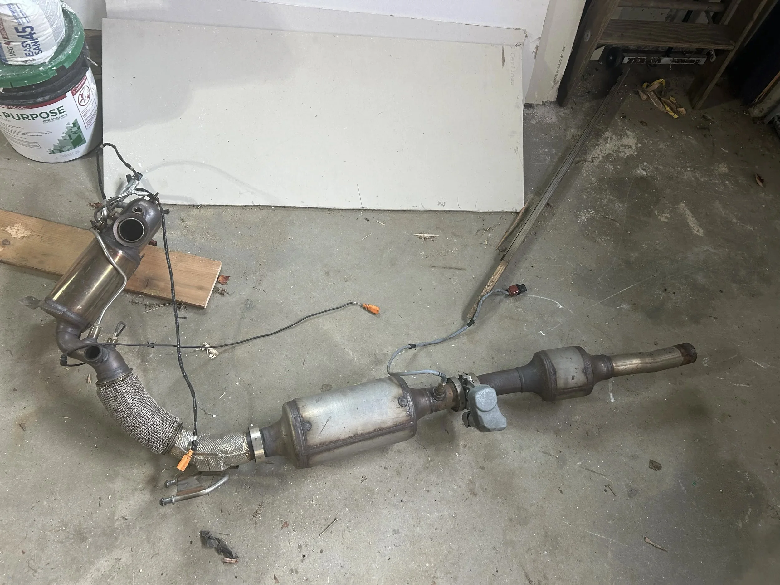  Part of an emissions system rests on the floor of a garage in Northwood, N.H. on October 13, 2026. (Echo/Ryleigh Johnson) 
