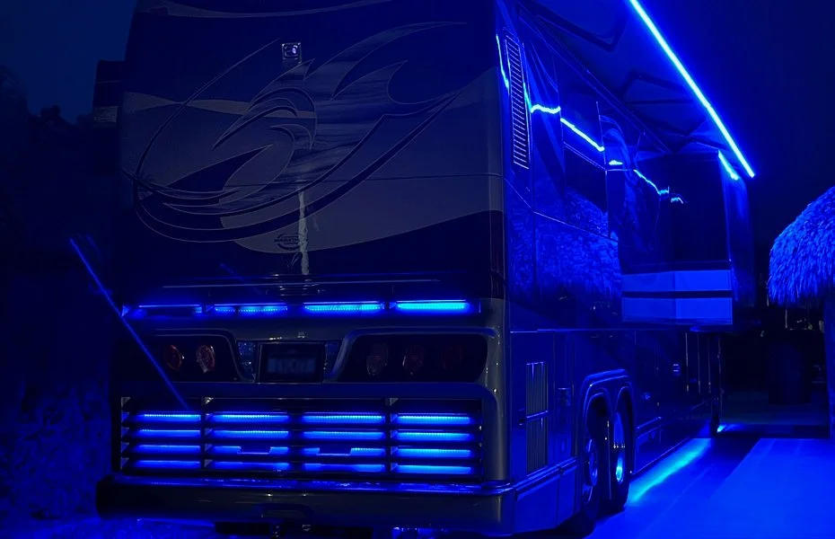 Rear view of a luxury coach at night showcasing custom blue back-lighting.