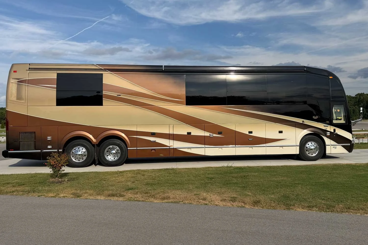 Passenger-side view of the coach on a paved lot.