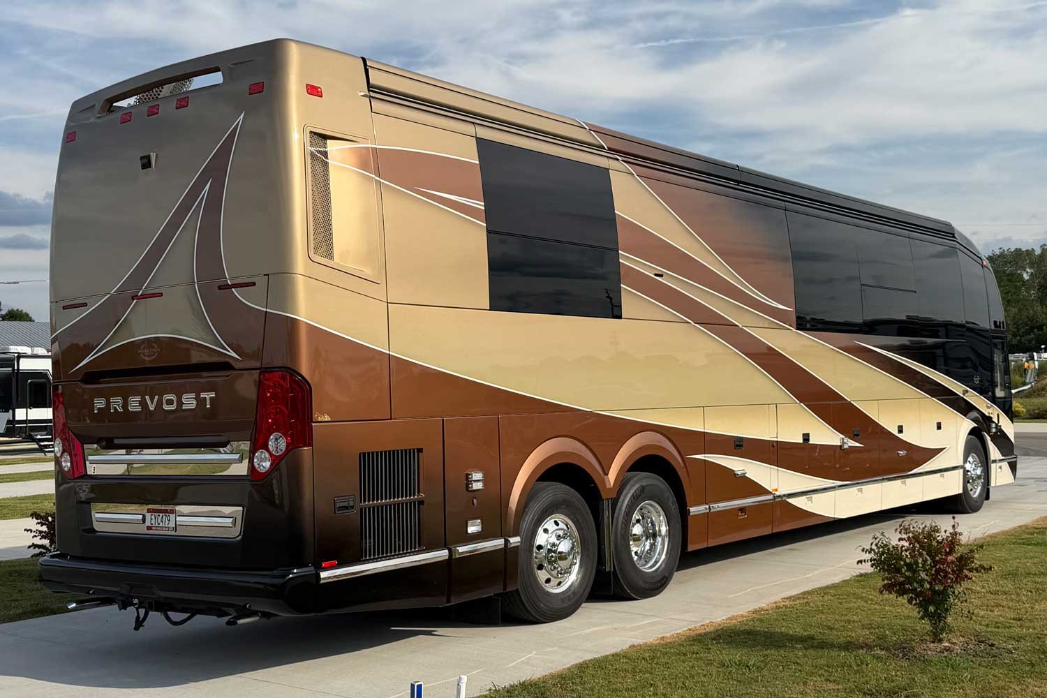 Rear passenger-side view showing the Prevost badge and taillights.