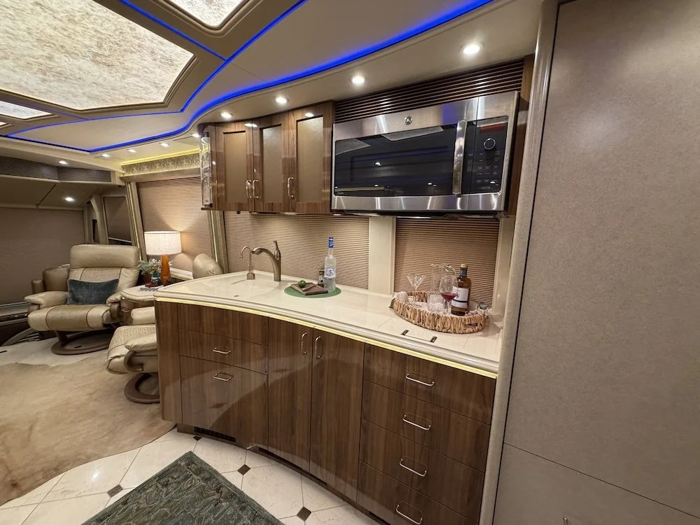 Kitchen and reclining seating area inside the 2019 Marathon Bunk Coach.
